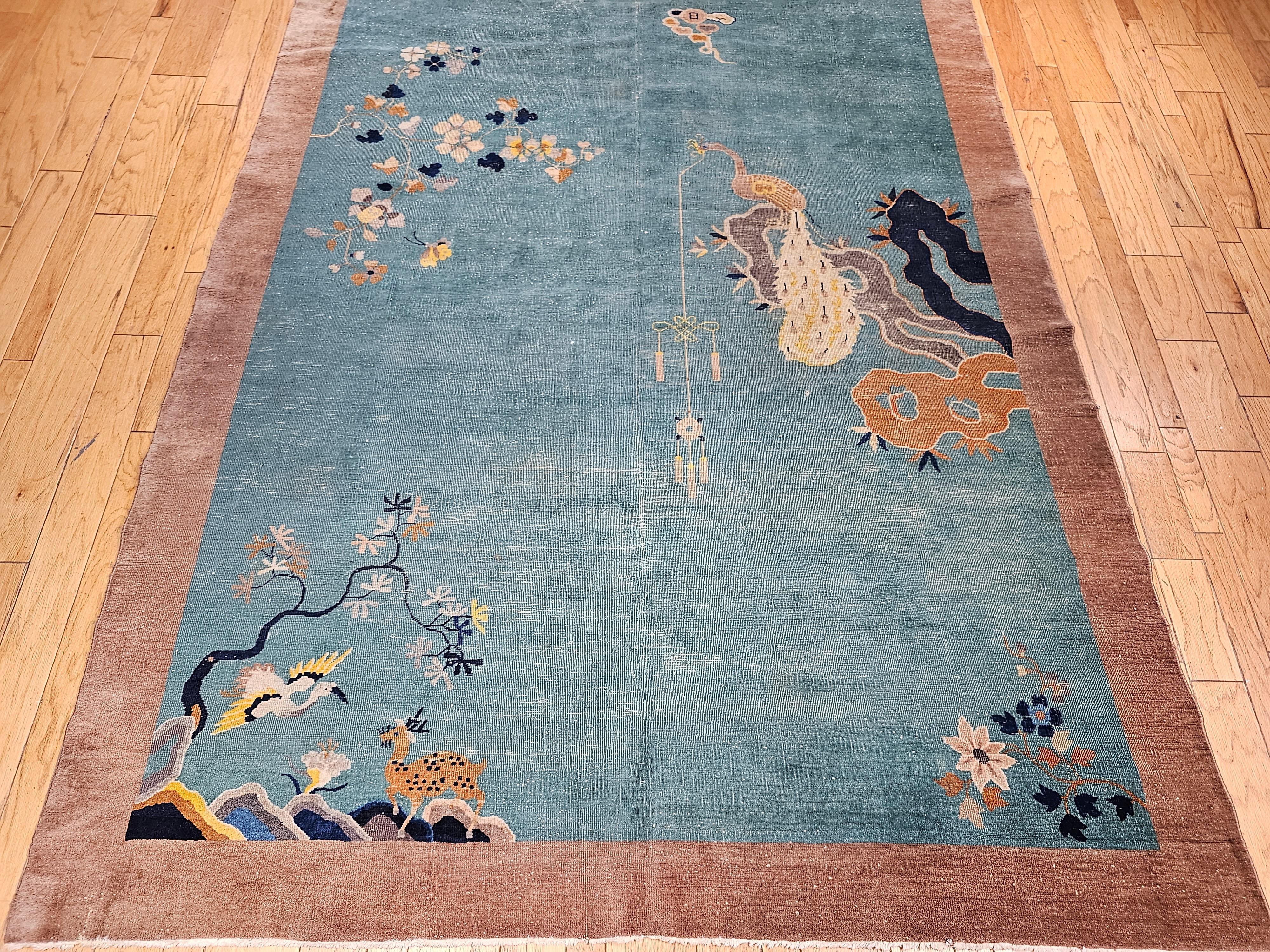 A beautiful hand-knotted Chinese Art Deco rug with birds and flower designs from the early 1900s.  This rug has a beautiful pale tea/green field color with lush floral design perfusing throughout the field in gray, blue, red, yellow, and cream