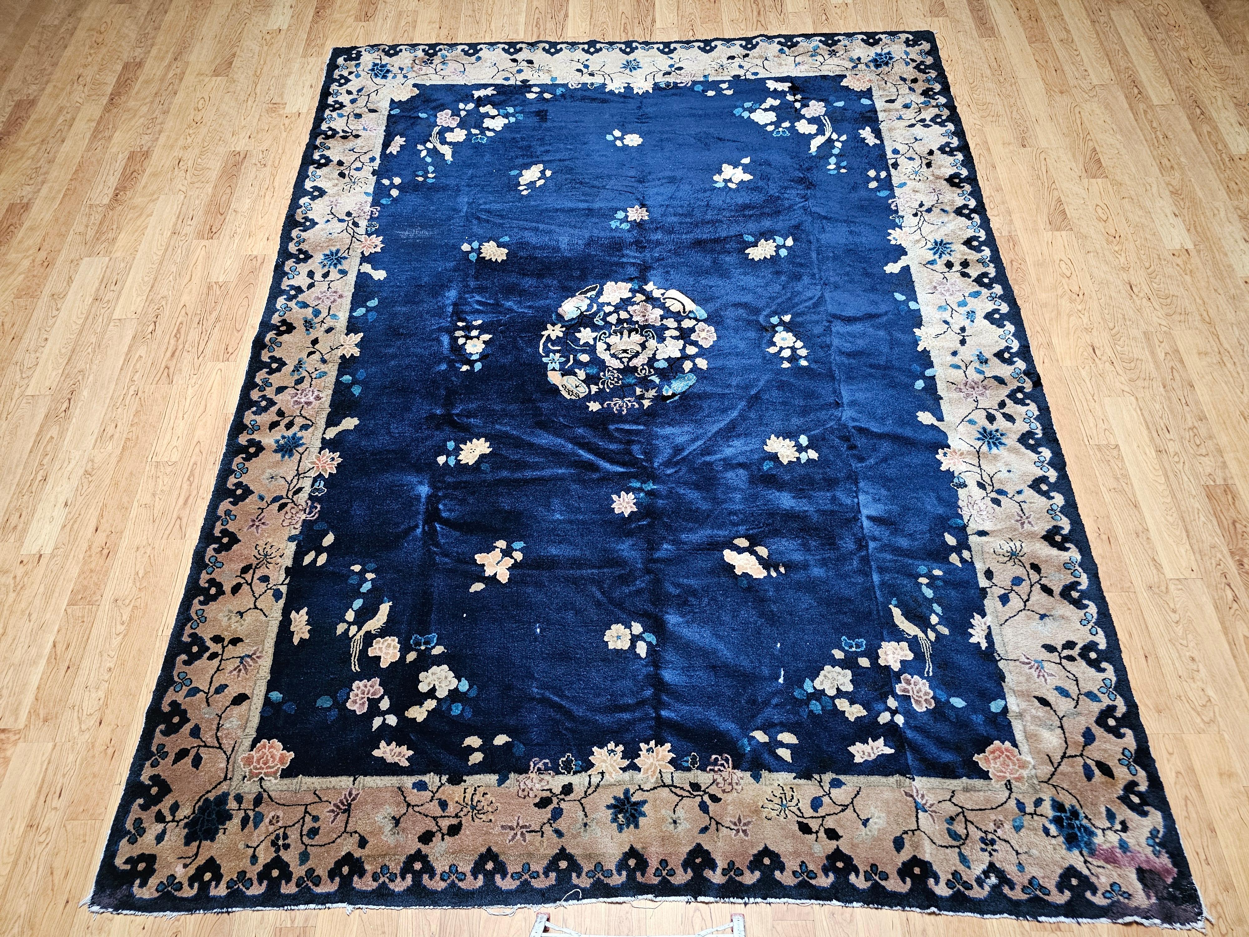 A stunning example of early 20th-century Chinese Art Deco design, this hand-knotted vintage rug brings refined elegance and artistic charm to any interior. The spacious room-size format features a serene navy blue field accented with delicate bird