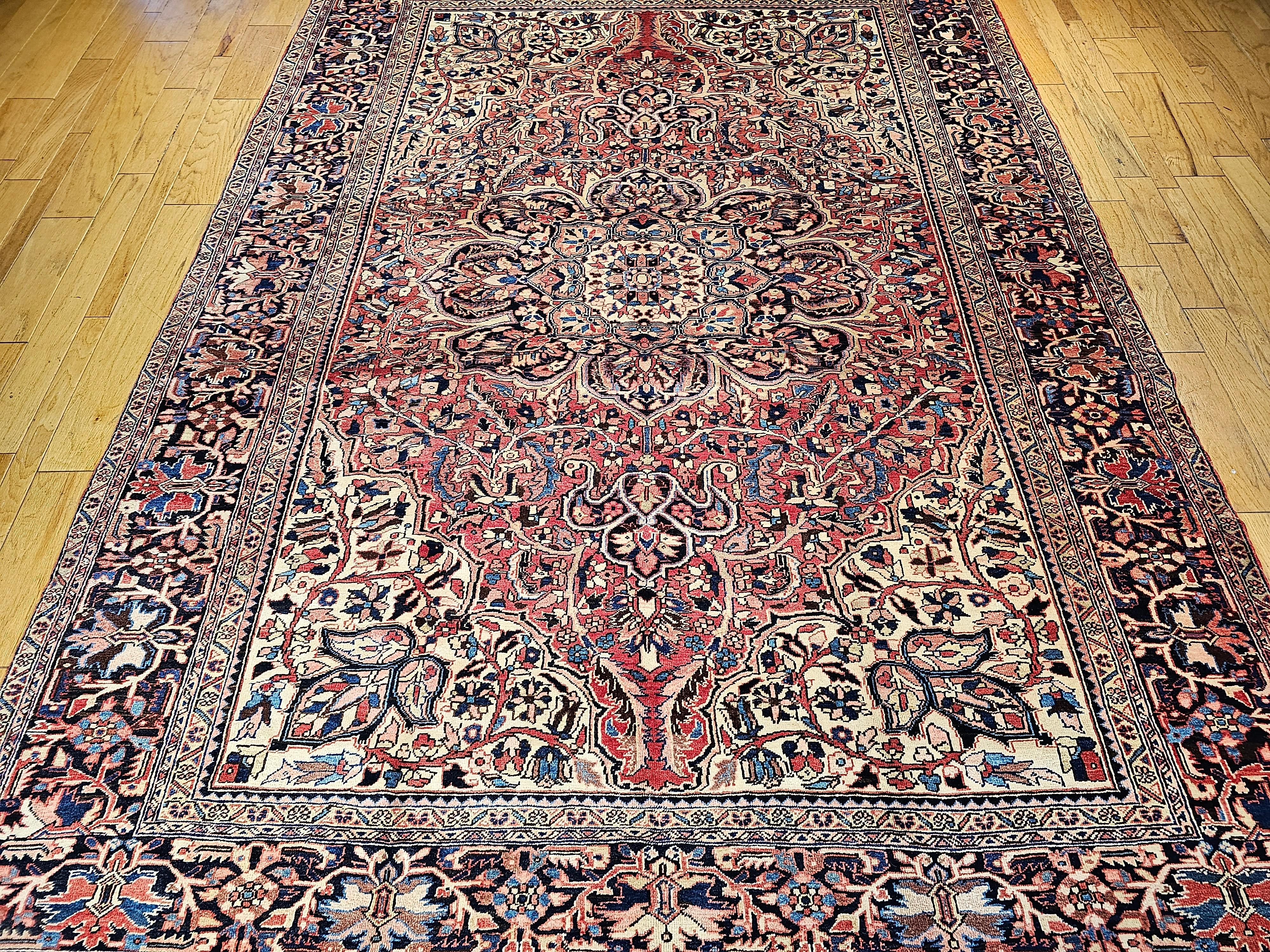 A room-size Persian Heriz from the Azerbaijan region of Northwest Persia from the mid 1900s. This Heriz rug has a beautiful rustic red background on which a wonderful array of colors are used.  The room-size Heriz rug has a large central medallion