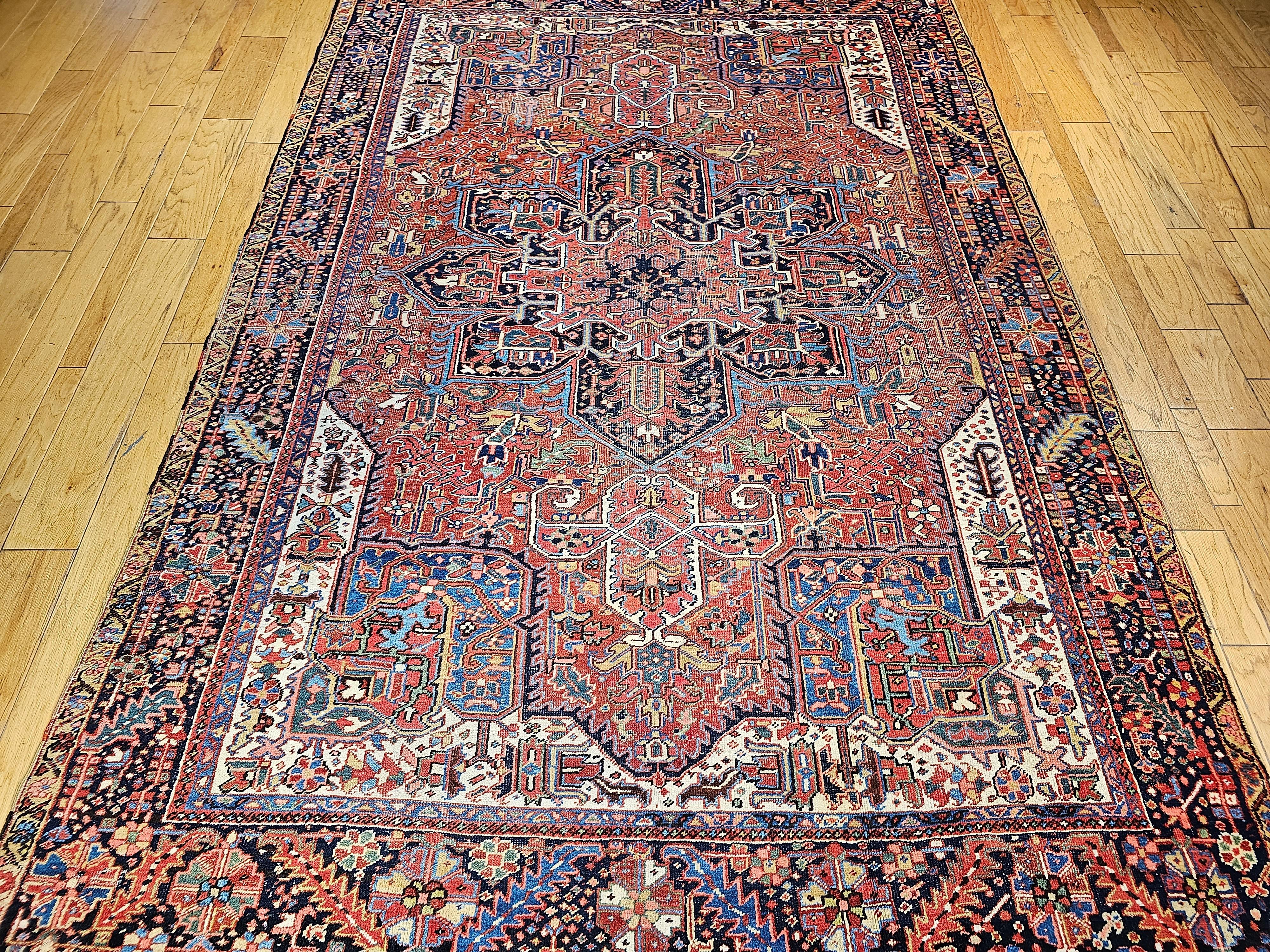 Vintage Persian Heriz from the village of Karajah is astonishingly beautiful!  One is mesmerized by the range and variety of colors in the rug produced by natural vegetable dyes.  The rug has a brick or rust-red field color with a navy blue border. 