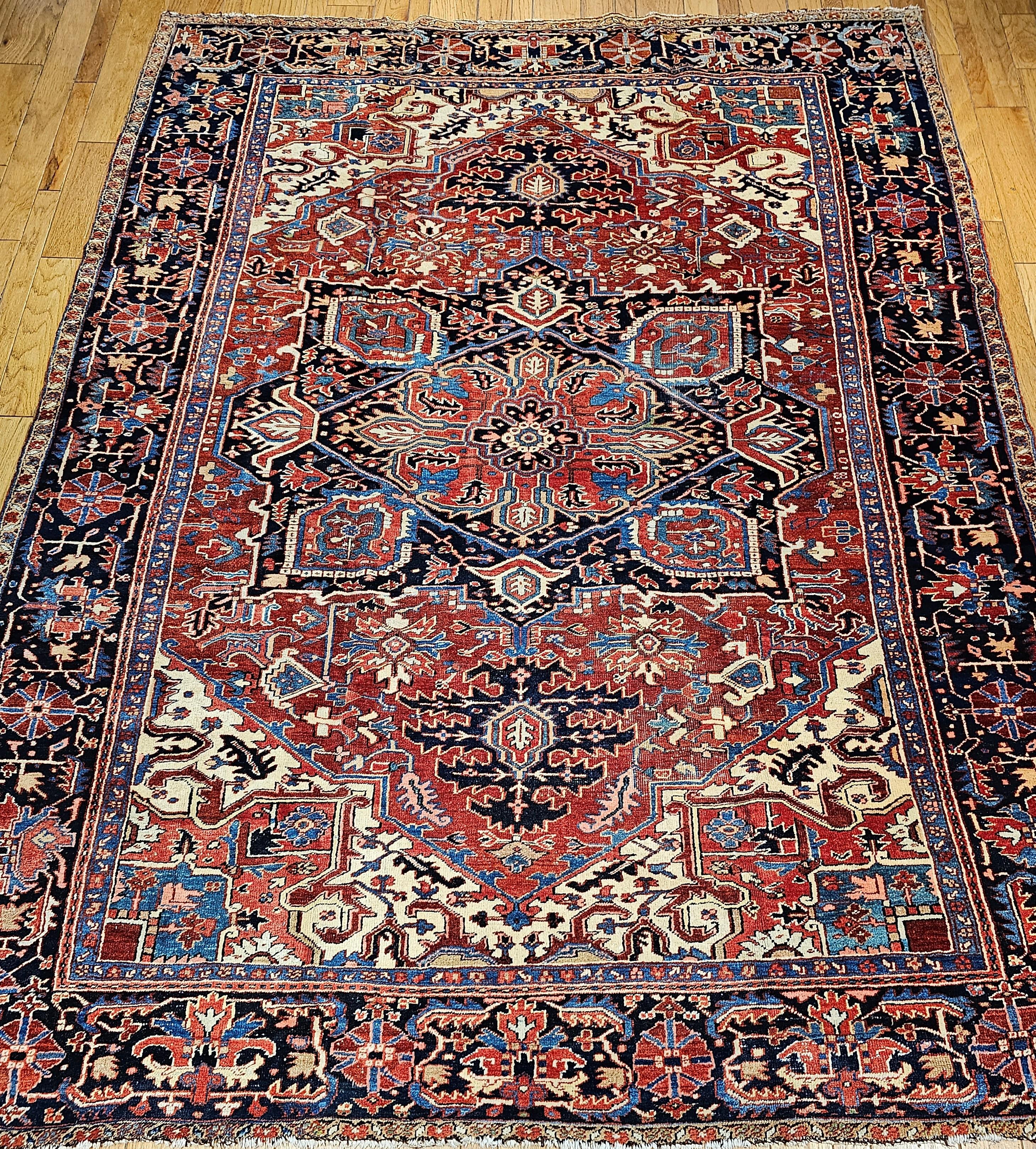  A wonderful example of village weaving from NW Persia is represented in this room-size Heriz Serapi rug from the late 1800s.  The rug has dark red field color with corner spandrels in beautiful French Blue and pink colors.  The central medallion