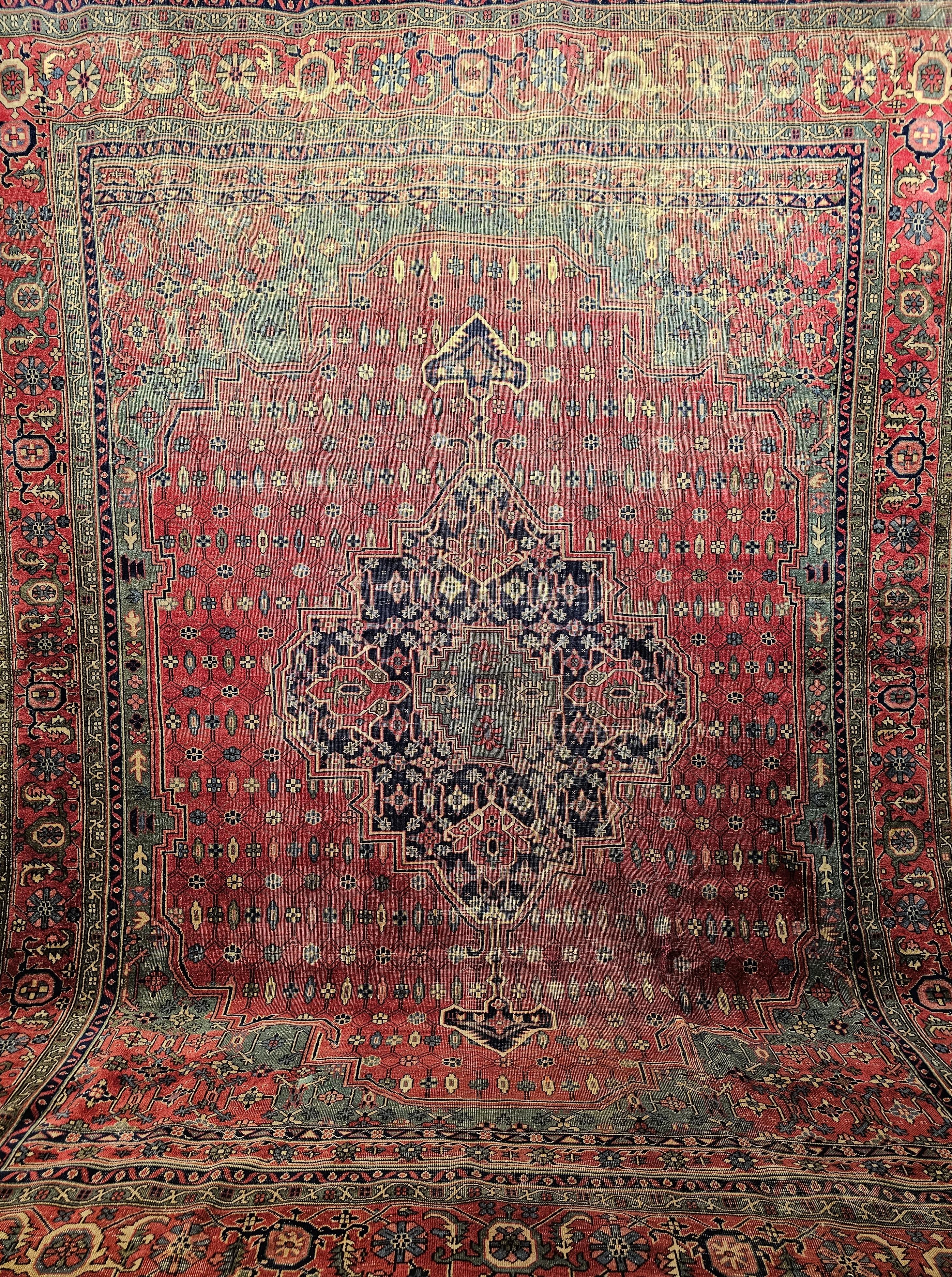  A Turkish rug in the Persian Heriz geometric medallion design.  The  room size rug has a beautiful and unique design and great colors.  The rug has a central medallion in navy blue, red and green colors set in a red color field.  The small