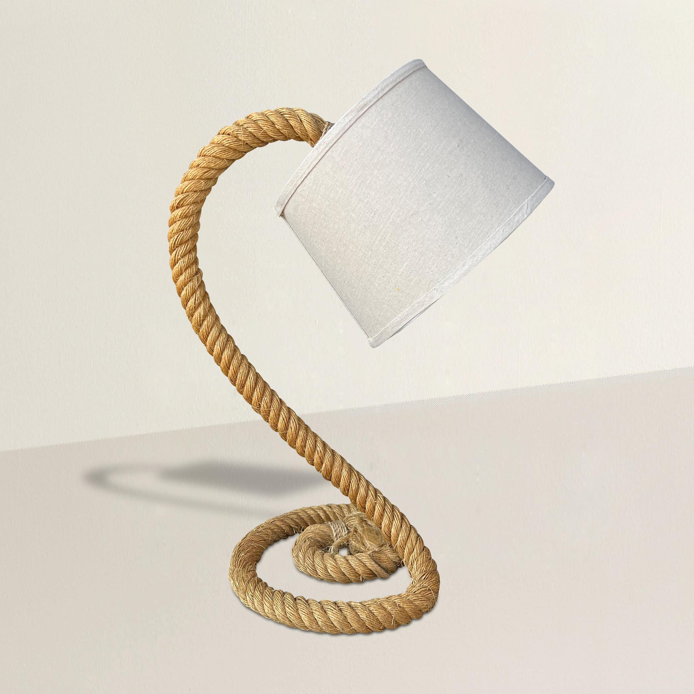 Introduce a touch of coastal charm to your living space with this vintage American nautical rope table lamp inspired by the iconic style of French designer Audoux-Minet. Crafted with exquisite attention to detail, this lamp captures the essence of