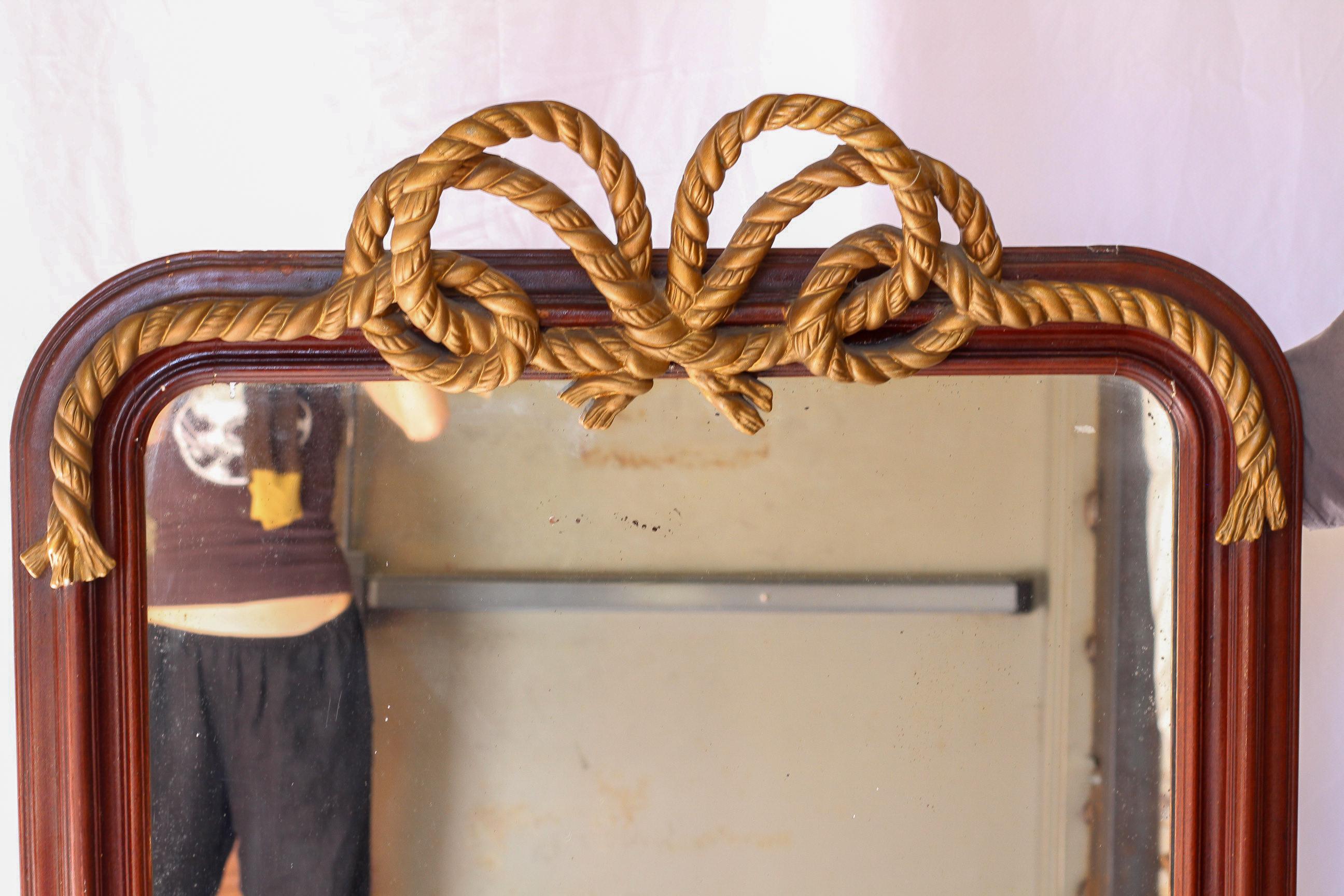 Este espejo de cuerda vintage tiene un marco de yeso dorado ornamentado que se asemeja a una cuerda retorcida, capturando la elegancia del estilo de la época de la Regencia. Sus ricos detalles y cálidos tonos dorados la convierten en un acento