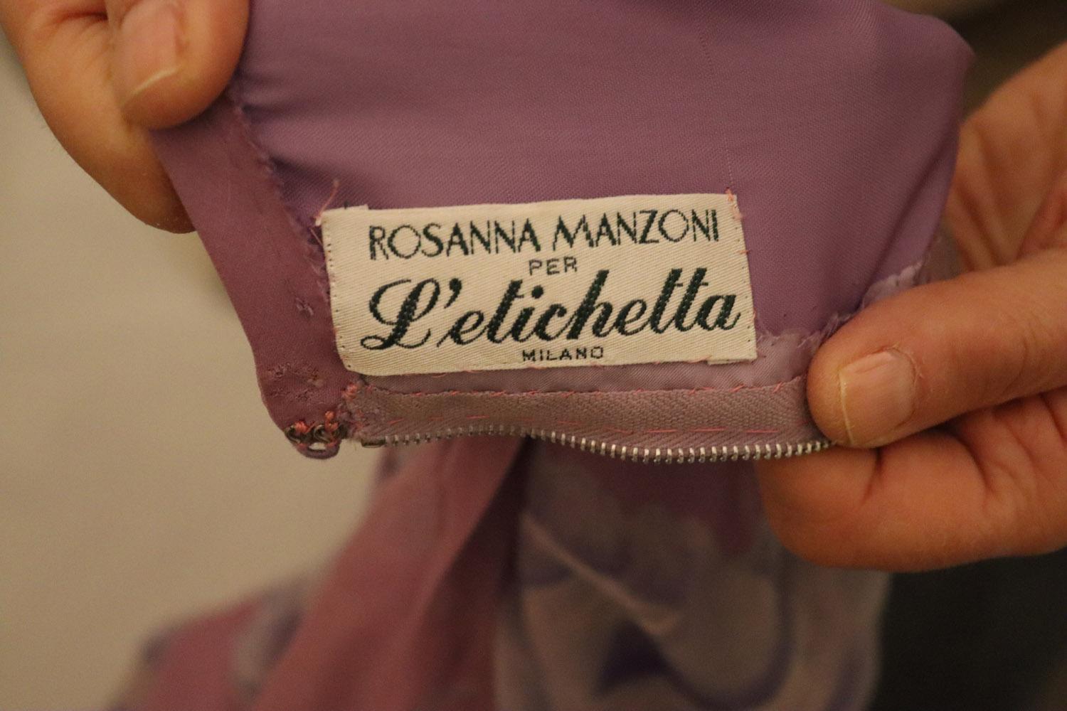 A stunning and very pretty silk gown by Rosanna Manzoni per L'etichetta, Milan. In a pretty lilac colour with a dusty blue /grey floral print. The gown has a round neckline, back central zip and sheer sleaves with three rows of frills. It is fully