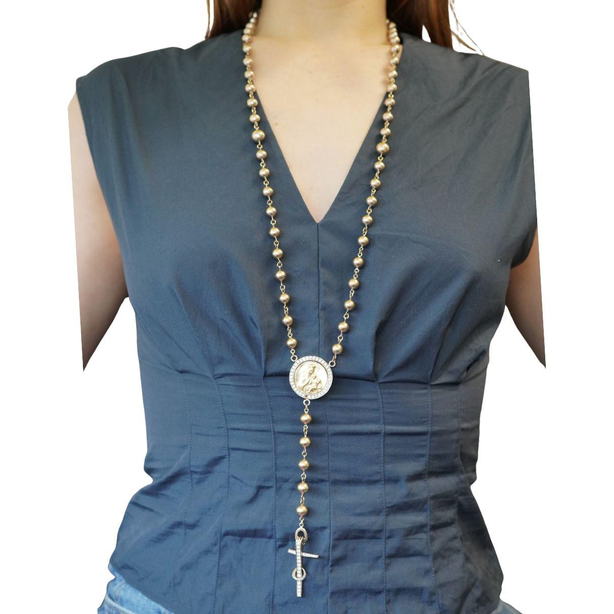 A two tone rosary necklace crafted in 18k gold, dating to the late twentieth century.
The design features a long strand of polished white and yellow gold beads leading to a central rotating medal that has Jesus on one side and flips to reveal an