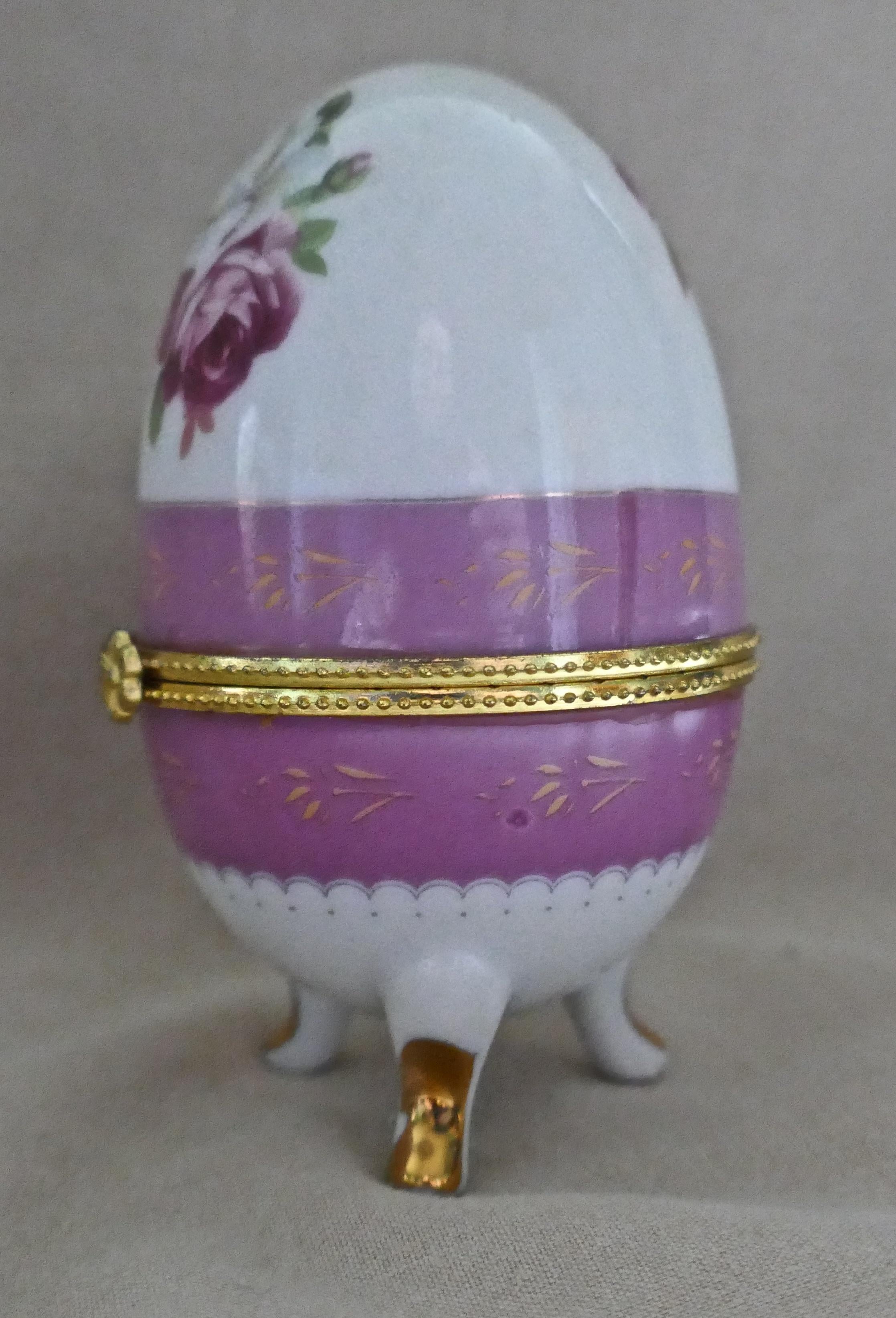 Vintage rose Chintz eiförmige Keramik Schmuckdose mit Scharnierdeckel

Dieses Keramik-Ei (Trinket Box) aus dem 20. Jahrhundert steht auf geformten Beinen und ist mit Rosen in Rosa und Gelb verziert.
Die Box ist in sehr gutem Zustand, der