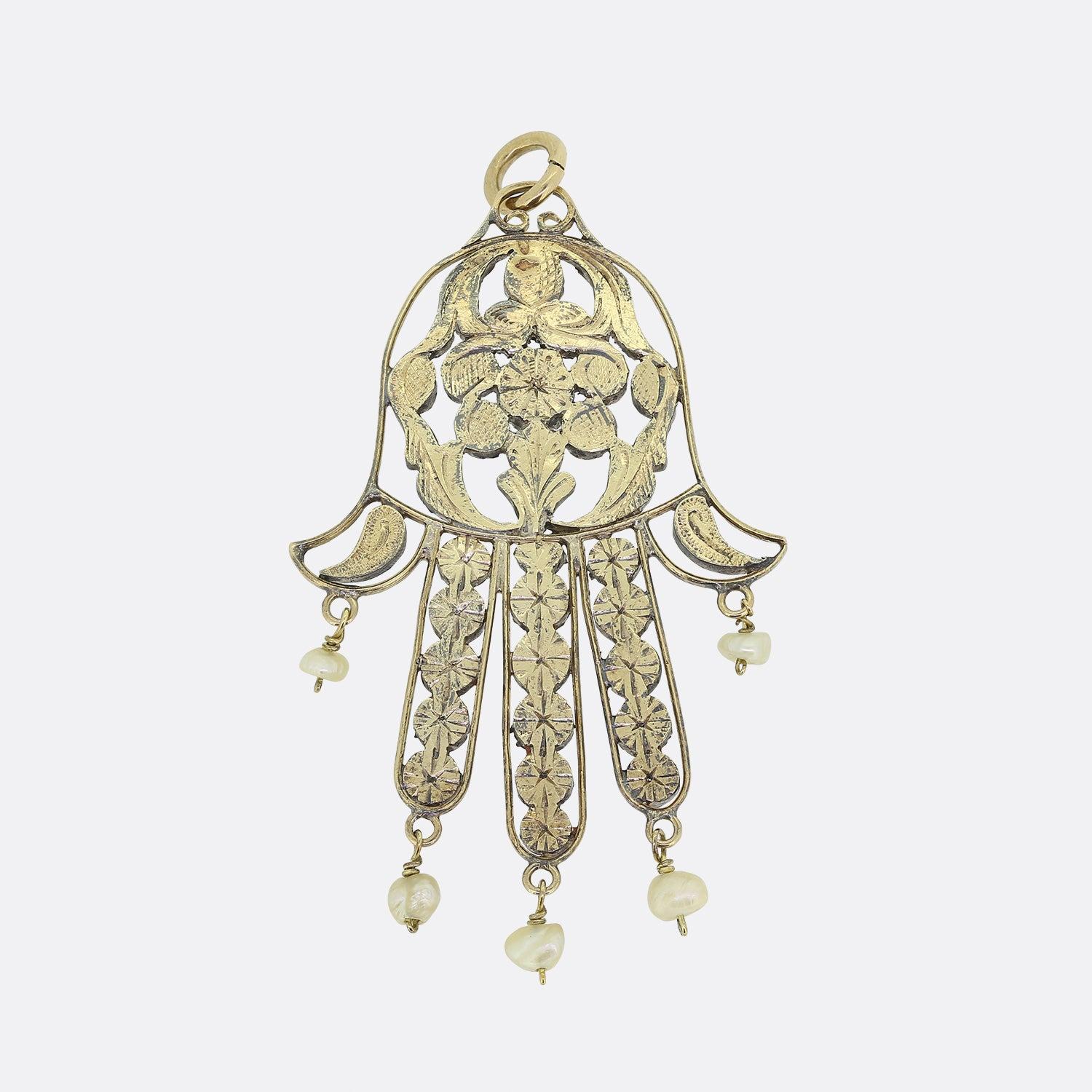 Here we have a lovely Vintage pearl and diamond pendant. This piece has been crafted into the shape of a Hamsa hand and has been set with an array of rose cut diamonds with pearl drops that hang from each finger. The back of the pendant has been
