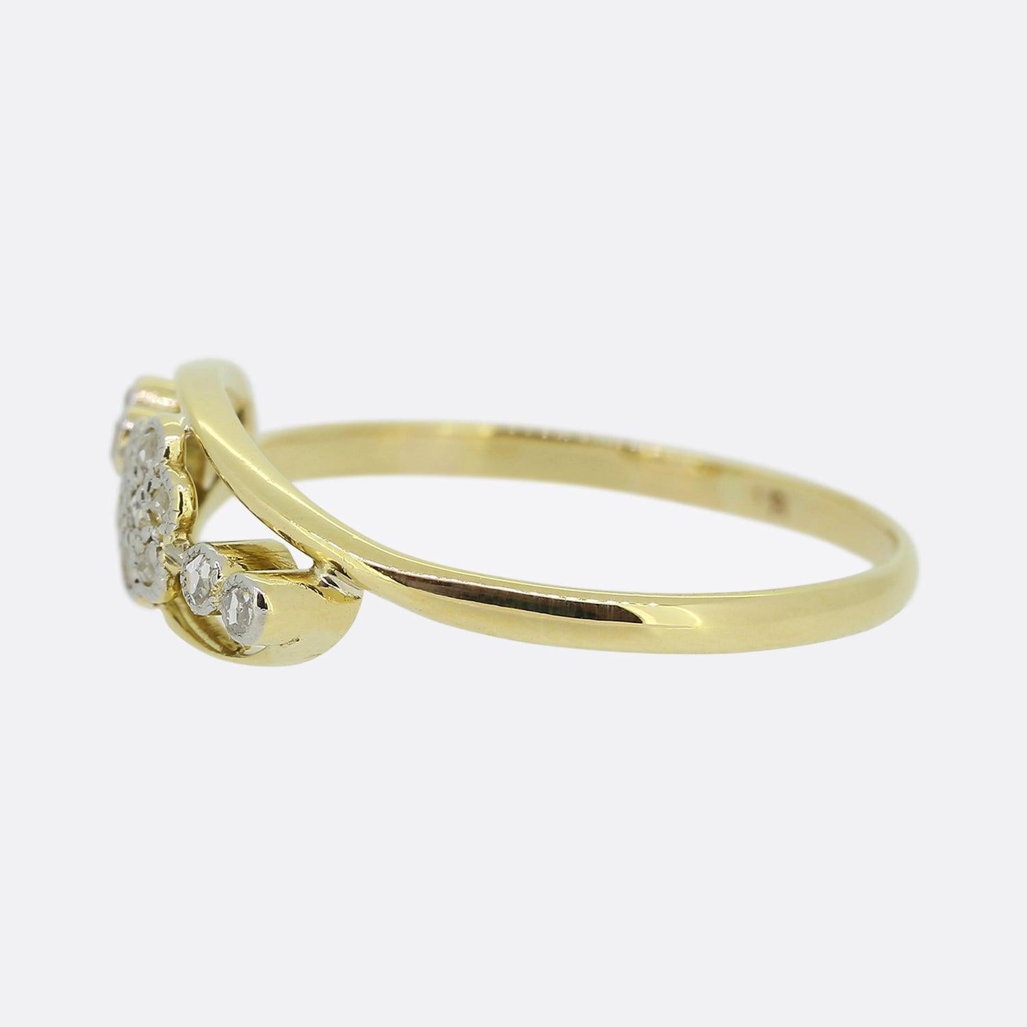 Here we have an elegant 18ct yellow gold diamond ring. An open frame plays host to a cluster of platinum milgrain set rose cut diamonds collectively forming a flower motif. This floral design is flanked on either side by an additional duo of rose