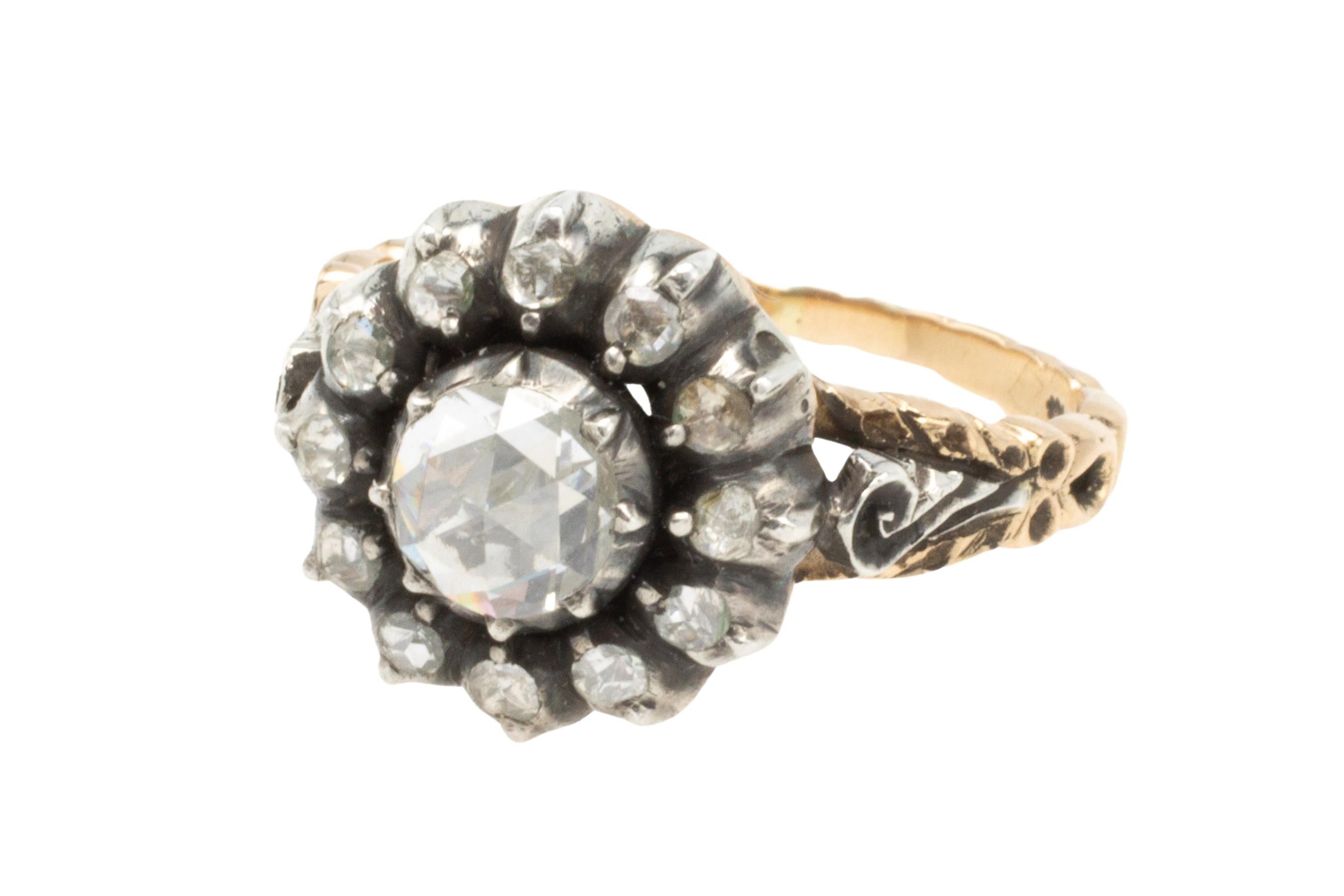 A classic Dutch vintage rose diamond entourage ring in silver and 14 carat gold.

The 13 rose diamonds are about .50 carat in total, the center stone has a diameter of 5.5 mm, the silver setting has a diameter of 7.5 mm.

The rose diamonds are in