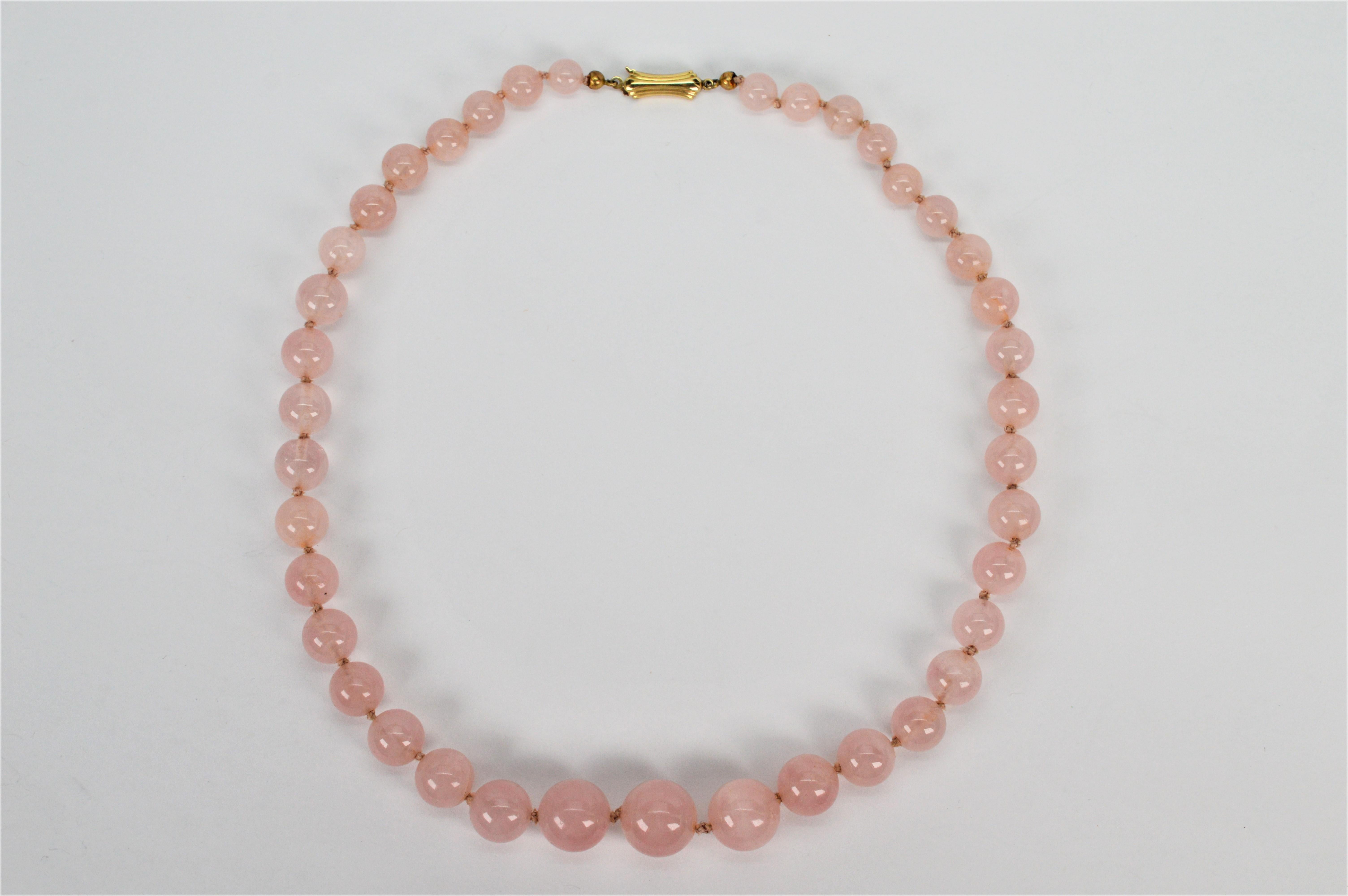 Abgestufte runde Perlen aus naturfarbenem Rosenquarz bilden diese schöne Vintage-Perlenkette. Neununddreißig runde, zartrosa Steine von 6,6 mm bis 13,2 mm werden von Hand auf den originalen Seidenstrang geknüpft, um seine Länge von 16 Zoll zu
