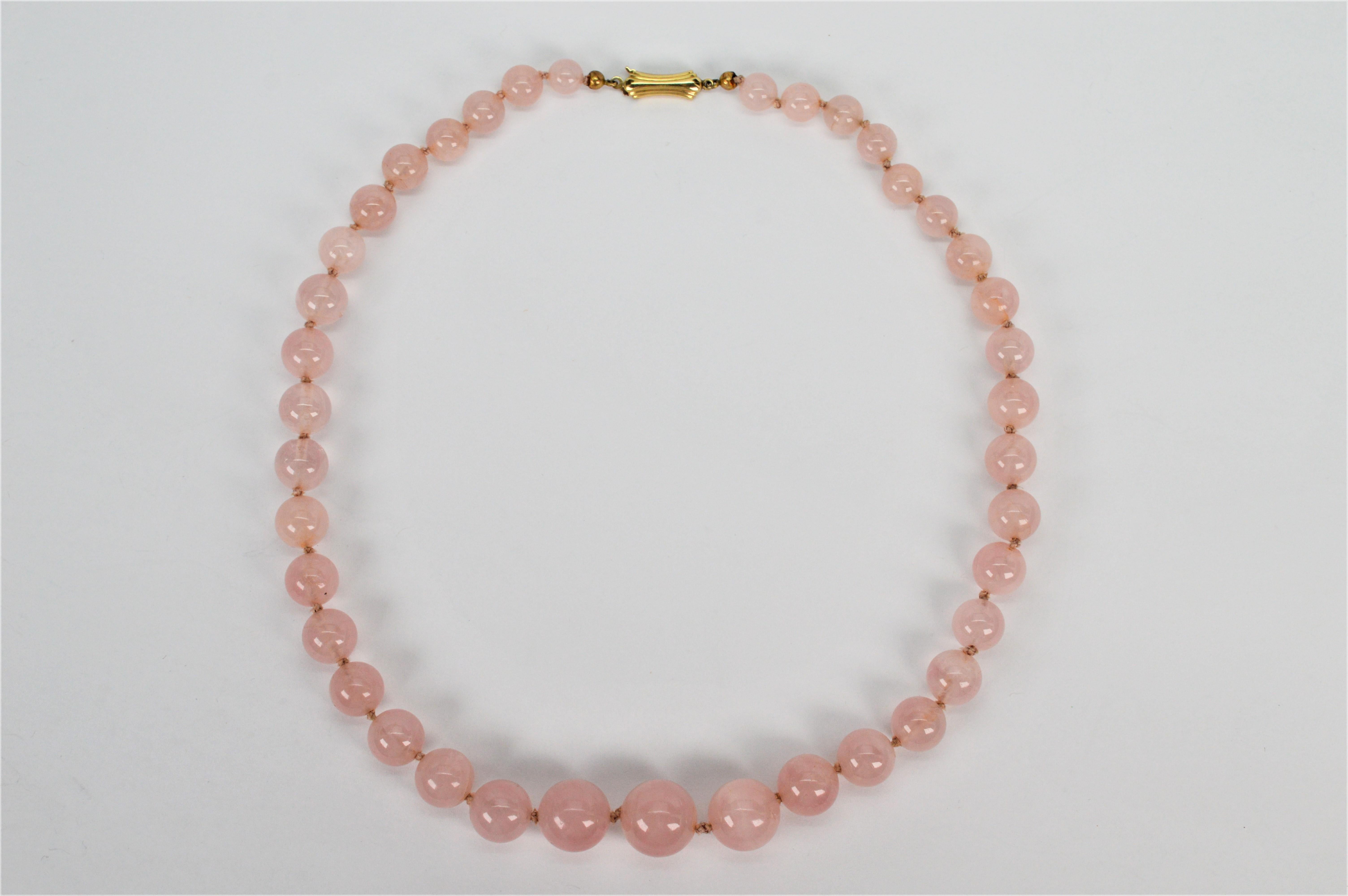 Perline rotonde graduate di quarzo rosa naturale color blush creano questa deliziosa collana di perline vintage. Trentanove pietre rotonde di colore rosa tenue, da 6,6 mm a 13,2 mm, sono annodate a mano sul filo di seta originale per creare la