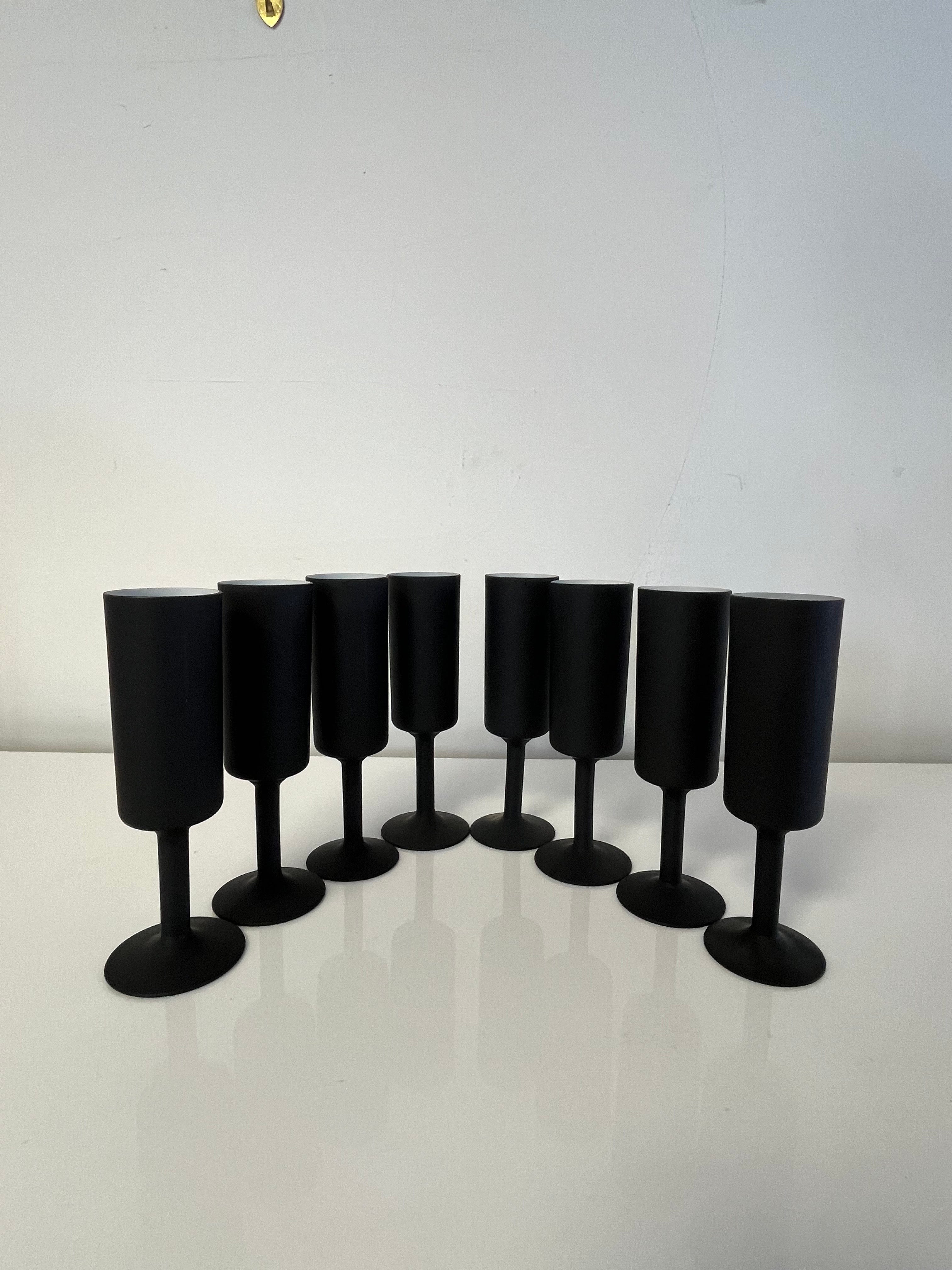 8 Striking black champagne flutes with contrasting white interiors. Sleek, slender design for sophisticated entertaining.