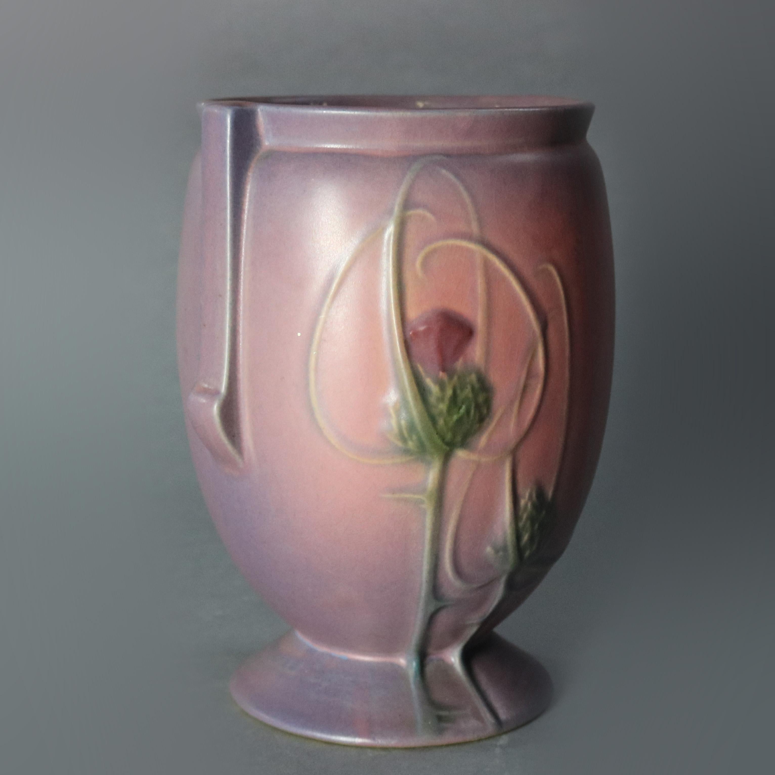 An Art Deco art pottery vase by Roseville of the Futura line offers double handled and footed vessel with thistle pattern in rare matte mauve and purple glaze, unmarked, circa 1930

Measures: 8