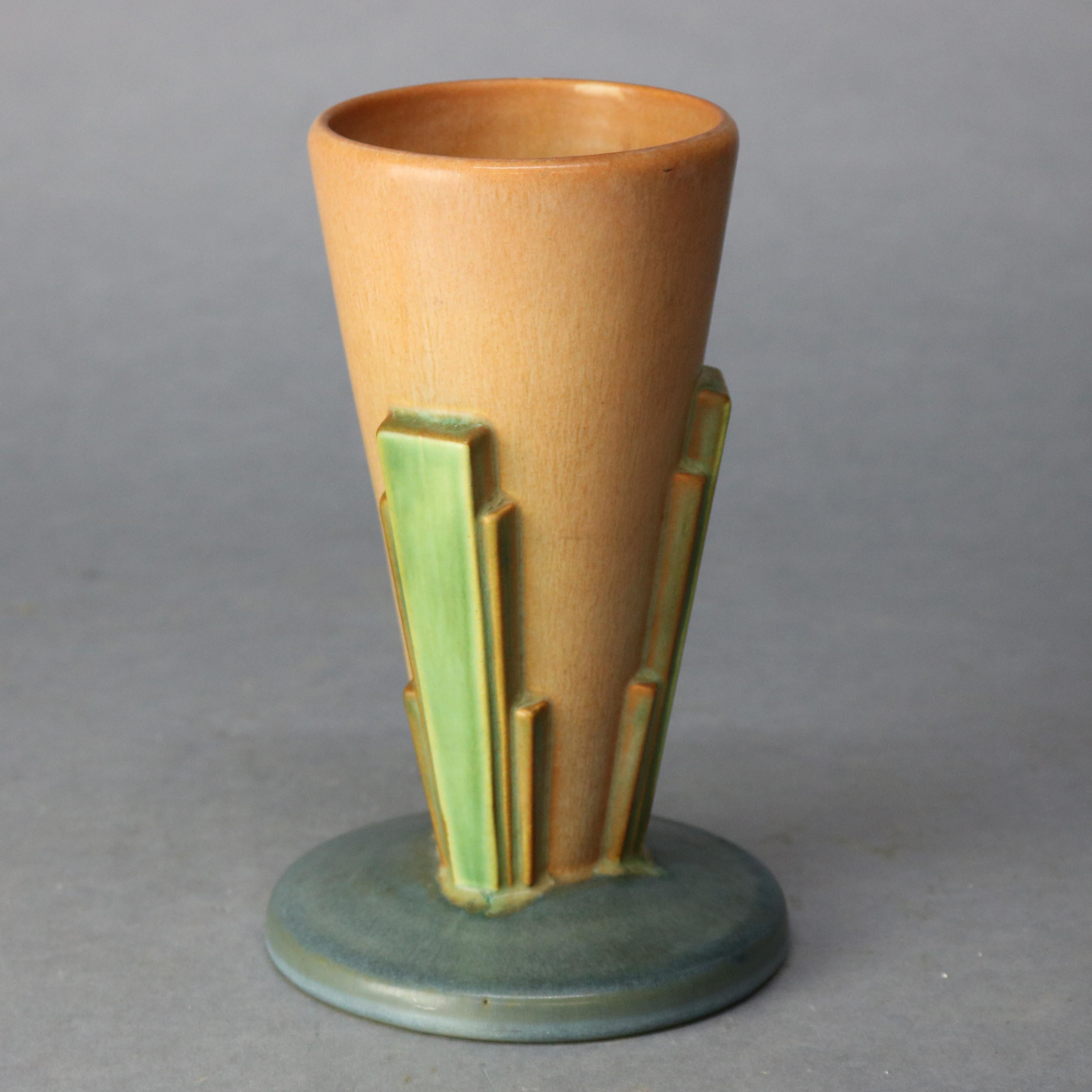 A vintage art pottery vase by Roseville of the Futura line offers stylized southwestern design with flared terracotta glazed vessel having four green buttresses in the manner of stylized dessert foliate elements, seated on round foot, unmarked,