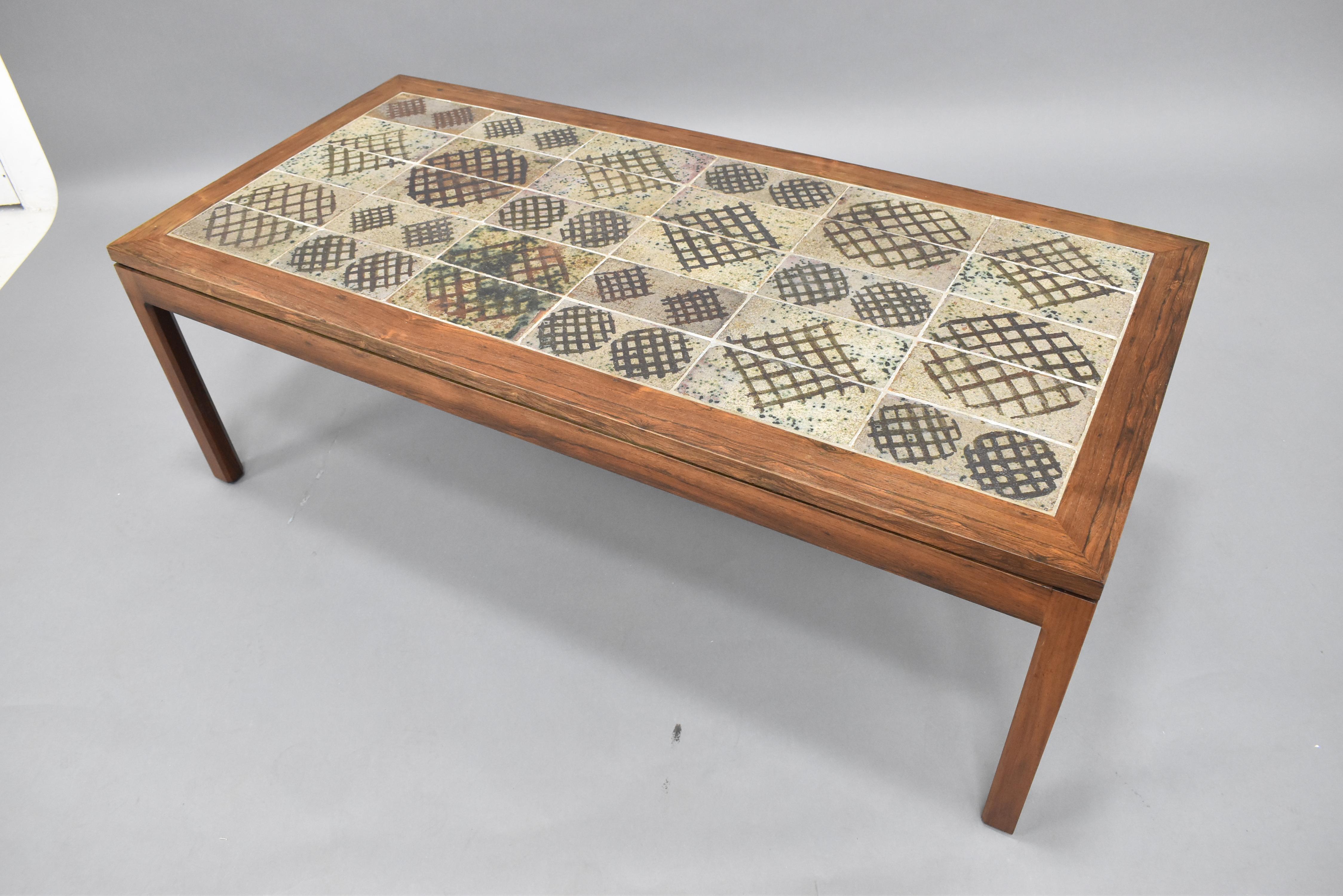 Very nice vintage coffee table executed in solid Rosewood with a beautiful ceramic tile top. Table frame is solid and raised on four legs, the tabletop has a slight reveal that appears to the top look like a floating slab on top of the base. The top