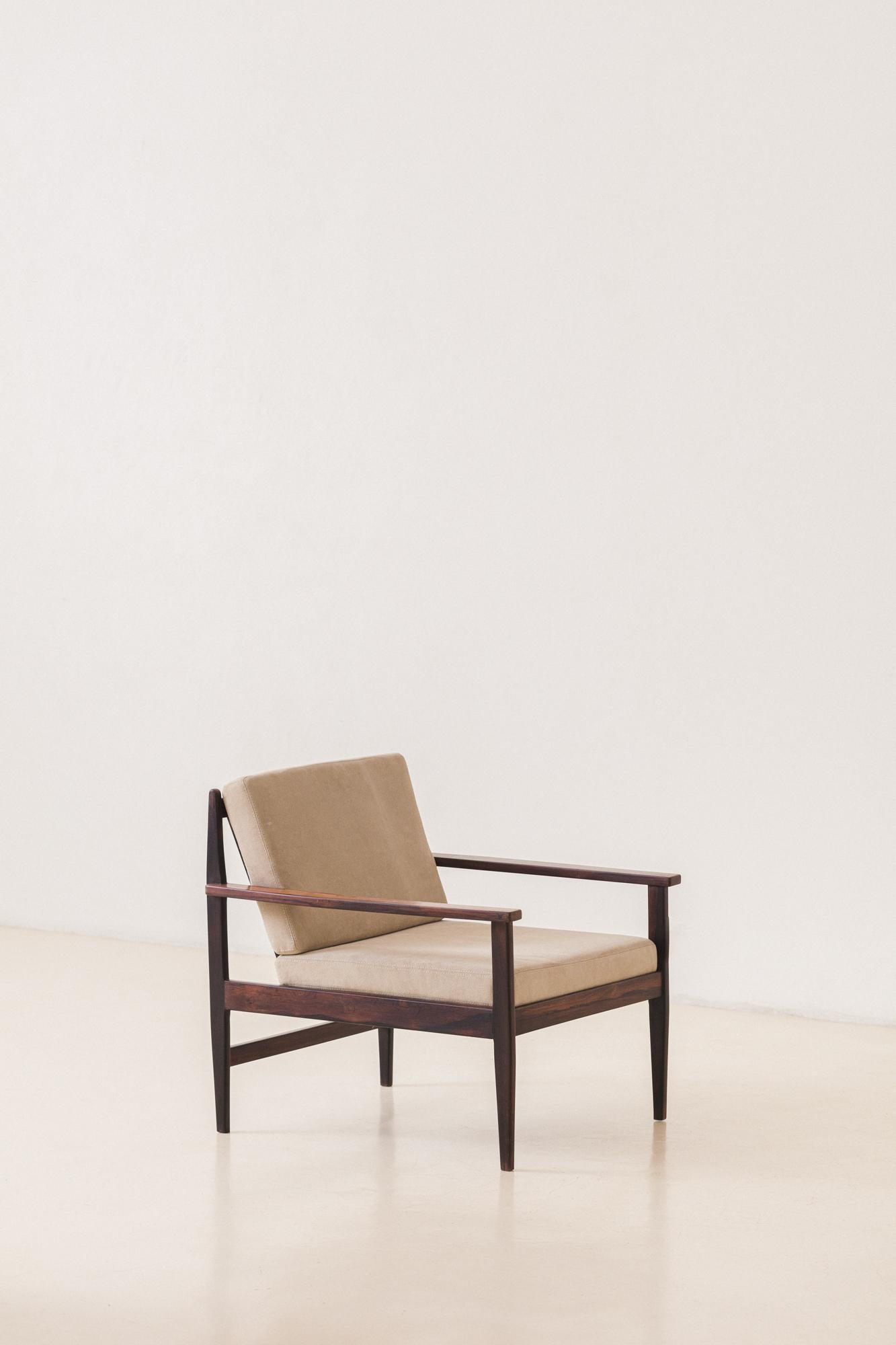 Dieser Sessel ist aus massivem brasilianischem Palisanderholz gefertigt und mit einer neuen Polsterung aus wunderschönem Veloursleder versehen. Die Armlehnen haben ein rechteckiges Design mit einer Rückseite aus vertikalen Latten. Dieses Modell