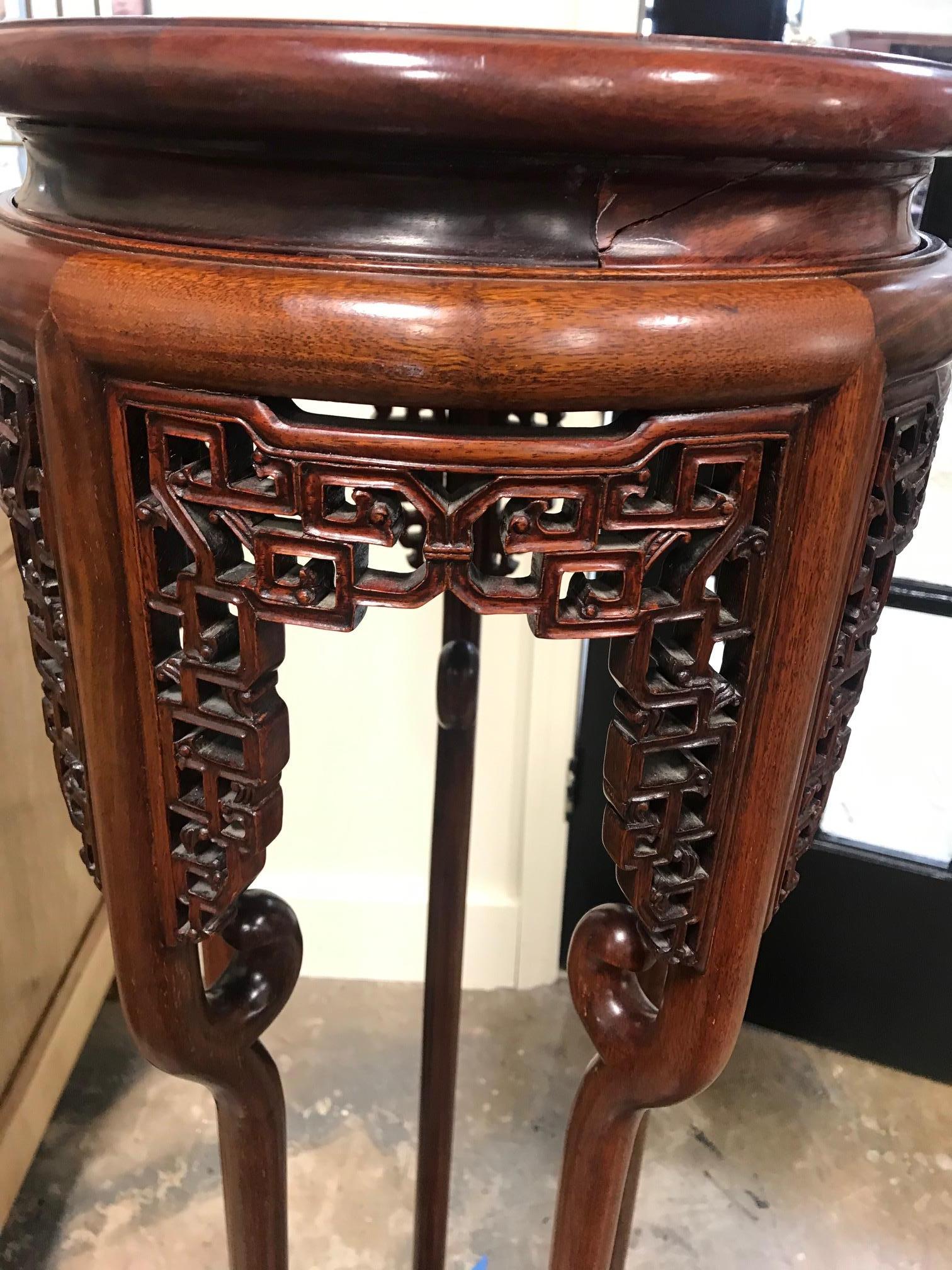 A beautiful rosewood plant stand which is heavily hand carved on the top and below.