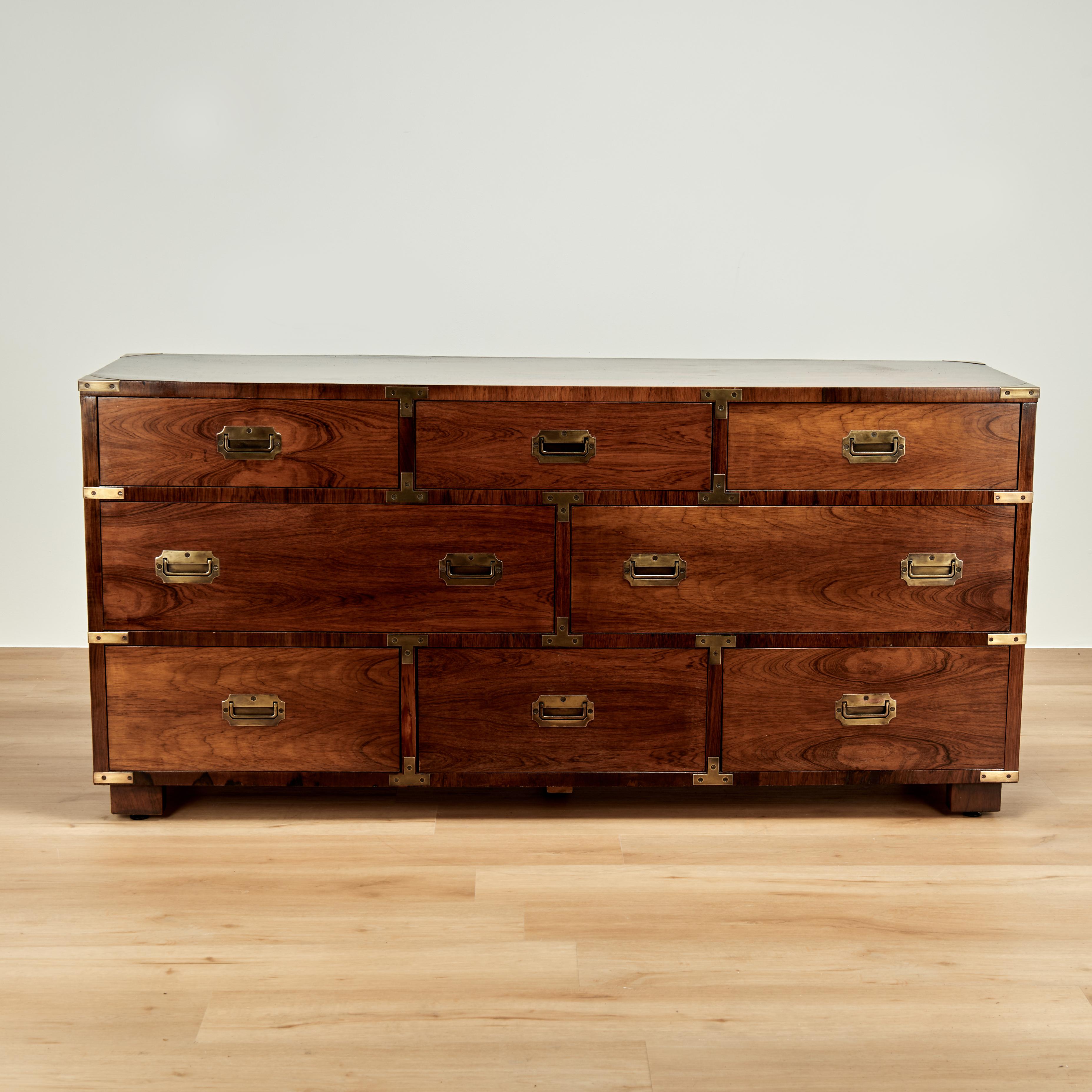 Bellissima cassettiera in stile Campaigner della metà del secolo, realizzata in legno di palissandro con venature spettacolari, otto cassetti con ferramenta in ottone Campaigner e piedini a blocco. Un perfetto connubio tra design tradizionale e