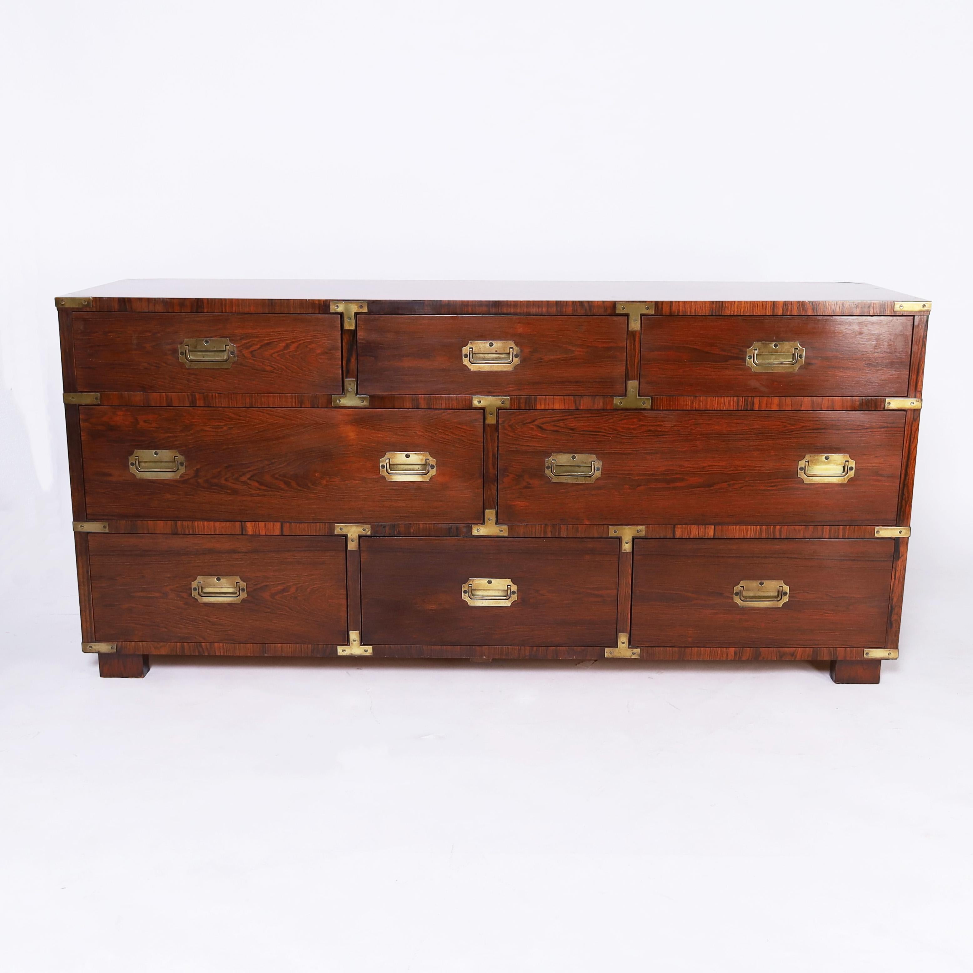 Chic Mid Century chest of eight drawers crafted in rosewood featuring bold dramatic grains, crossbanding, brass hardware, block feet and a perfect blend on traditional and modern design.