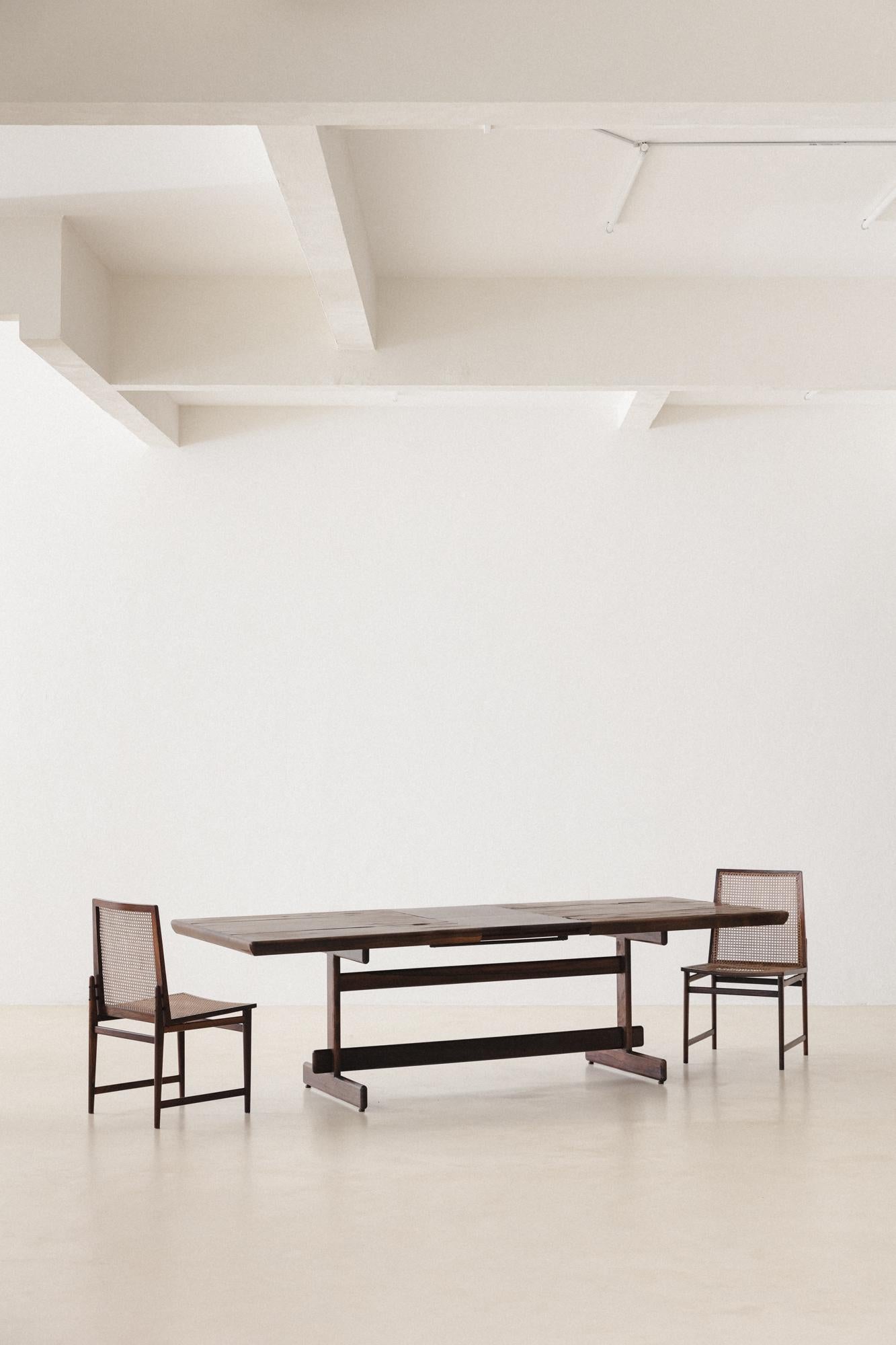 This Dining Table was produced by Cantù Móveis e Interiores Ltda. in the 1960s. The eight-seat table made of solid Rosewood with a veneered top is extendable for ten seats, with a practical engine at the table's center.

Architects Jorge Jabour