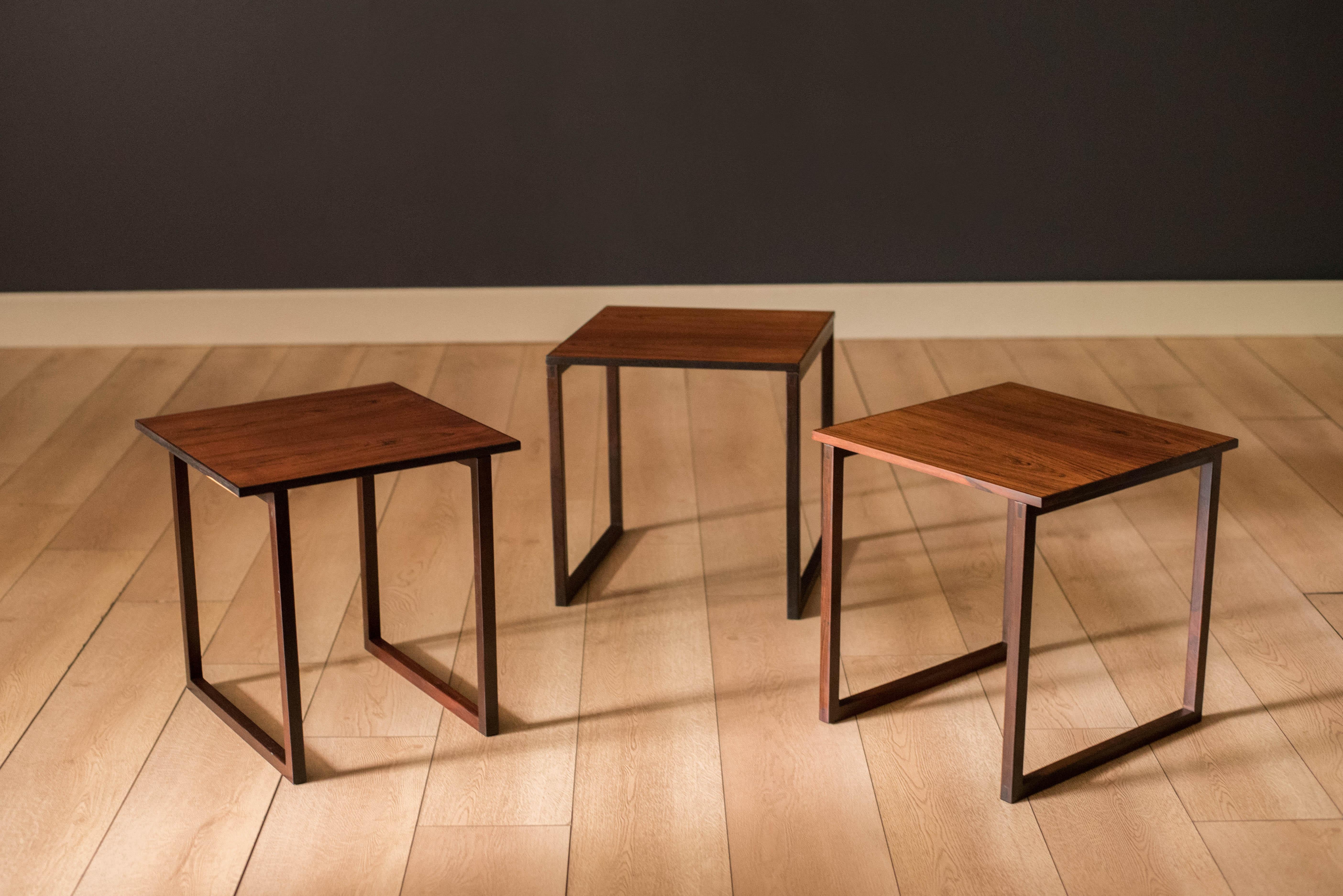 Mid-Century Modern stacking end tables designed by Kai Kristiansen for Vildbjerg Møbelfabrik, circa 1960s. Features natural rosewood grains and detailed joinery on the supporting bases. This set includes three square end tables that can be used