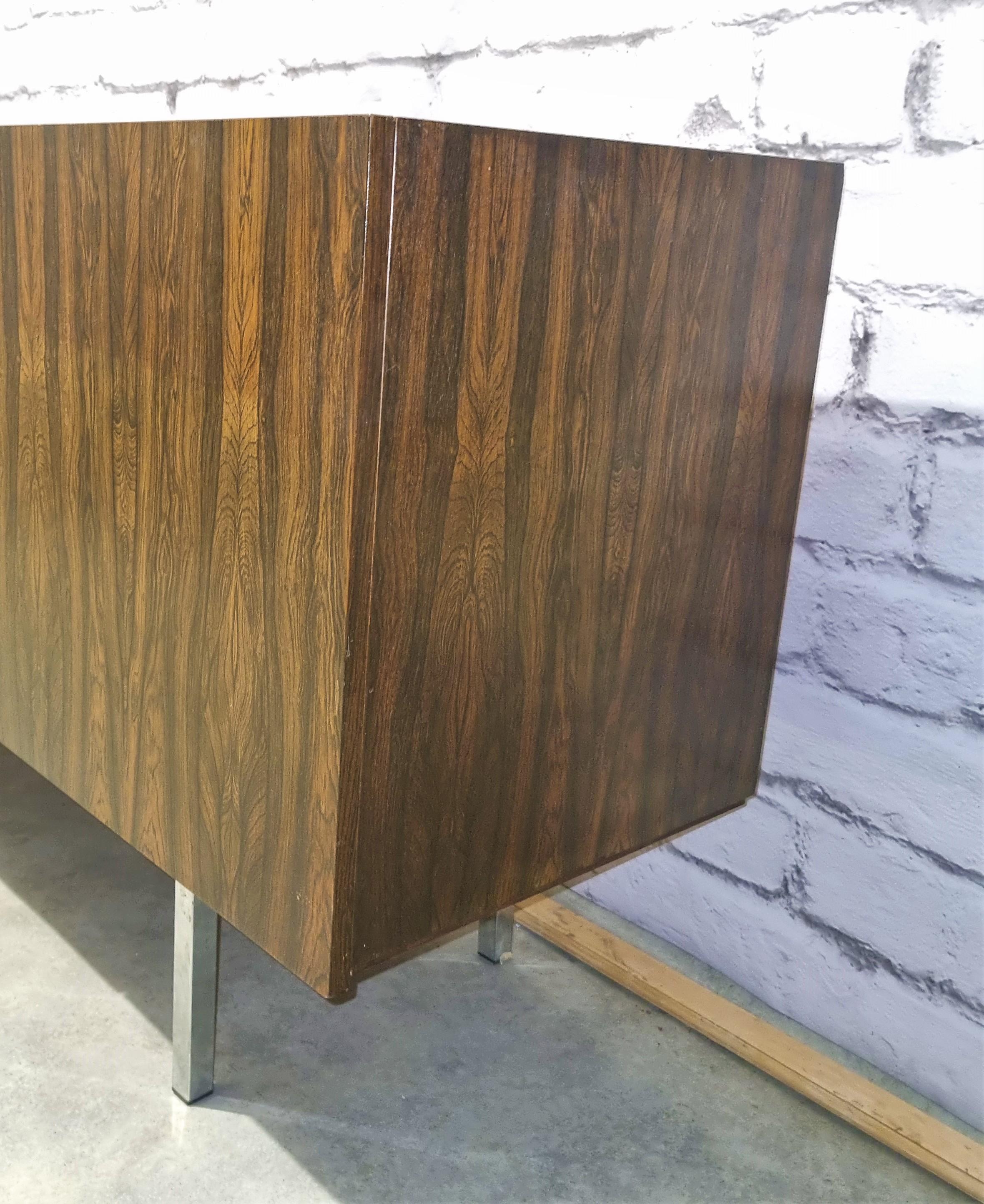 Exceptional Scandinavian sideboard in rosewood. This large piece of furniture opens with four doors revealing shelves on each side. It rests on 4 chrome legs. It is in very good condition with little signes of use according to its age.