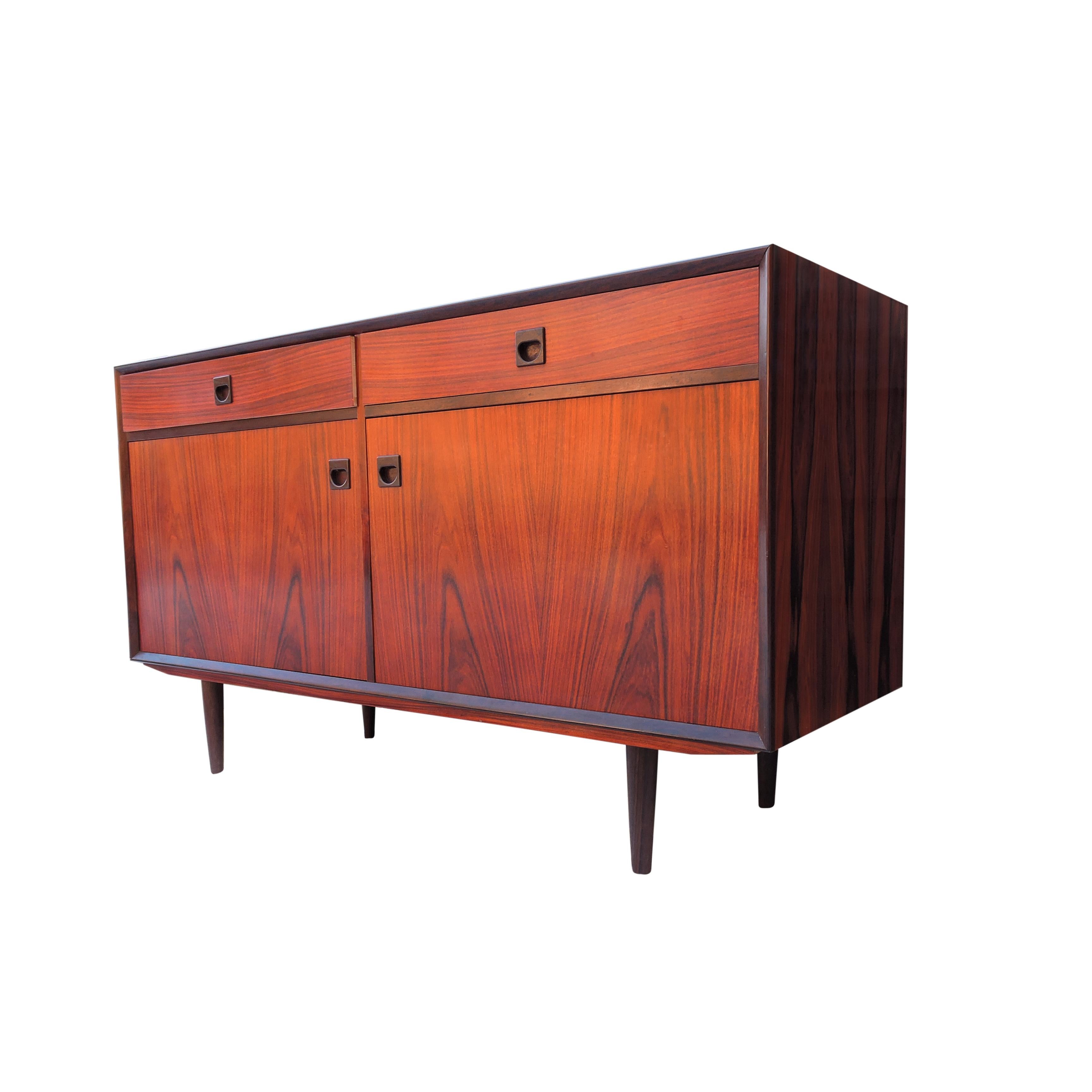 A rosewood sideboard featuring 2 drawers and 2 doors with inlayed handles.
 