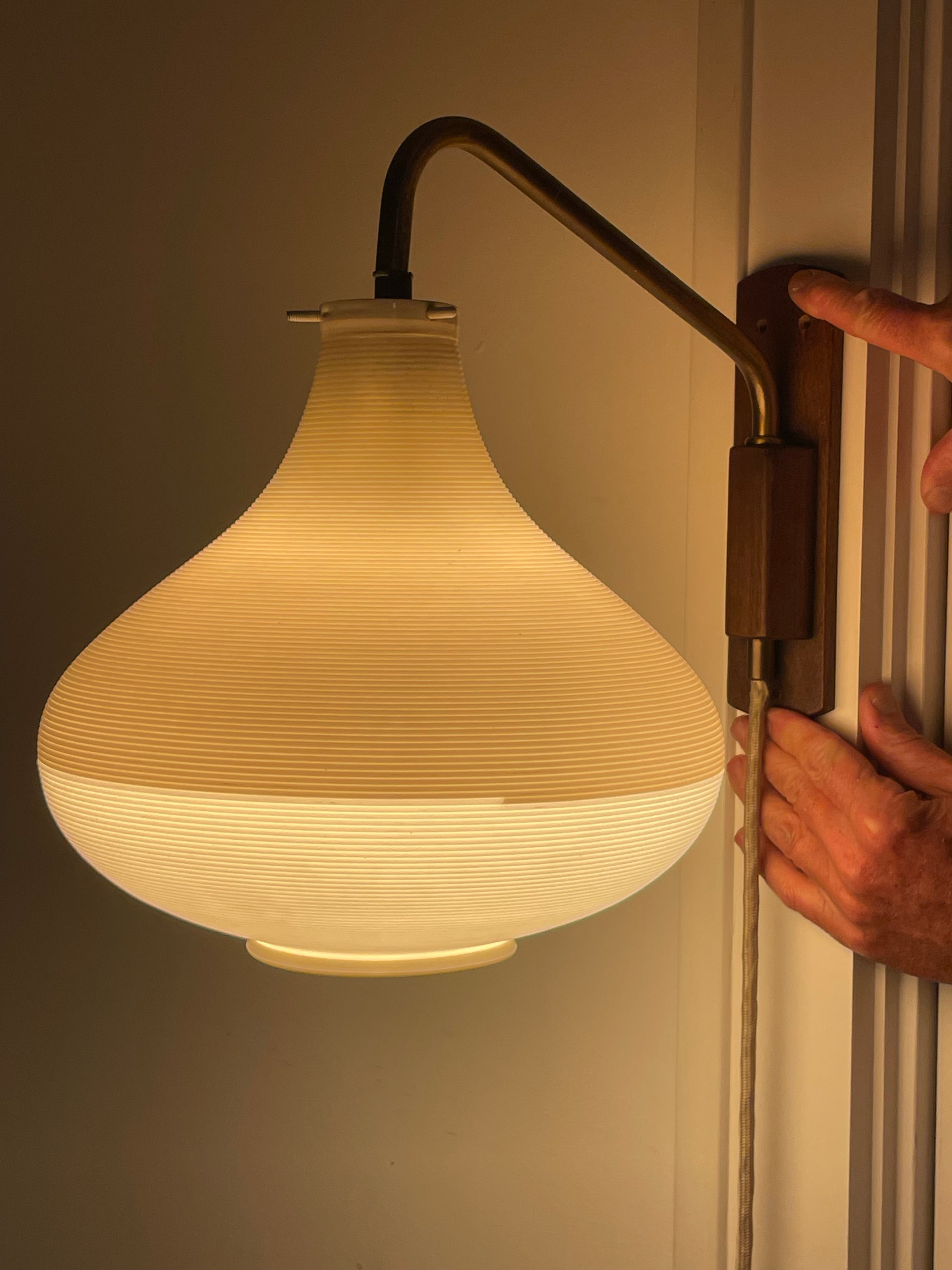 Este rarísimo y precioso aplique de pared de brazo orientable y pivotante fue diseñado por Yasha Heifetz. La pantalla rotaflex es un acetato de celulosa hilado de dos tonos, beige y crema. El brazo oscilante es de latón y una montura de madera de