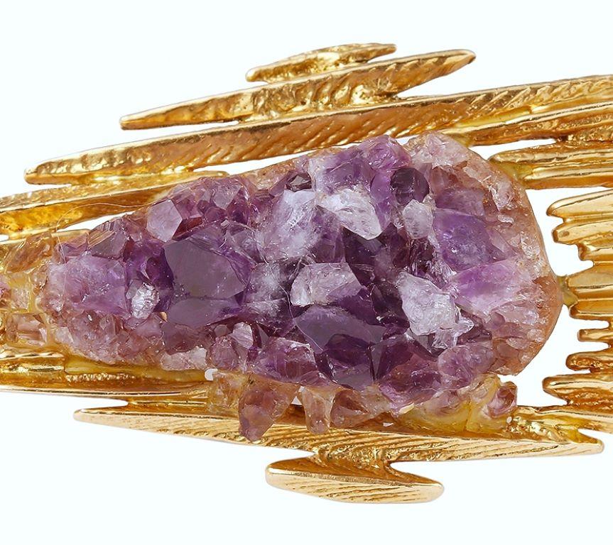 A large vintage yellow gold brooch set with a rough amethyst (traces of glue under the stone)

Secured clasp. 

Dimensions: 77.72 x 30.03 x 16.96 mm (3.060 x 1.182 x 0.667 inches)

18 carats yellow gold, 750/1000th (owl's hallmark)

weight: 26.80