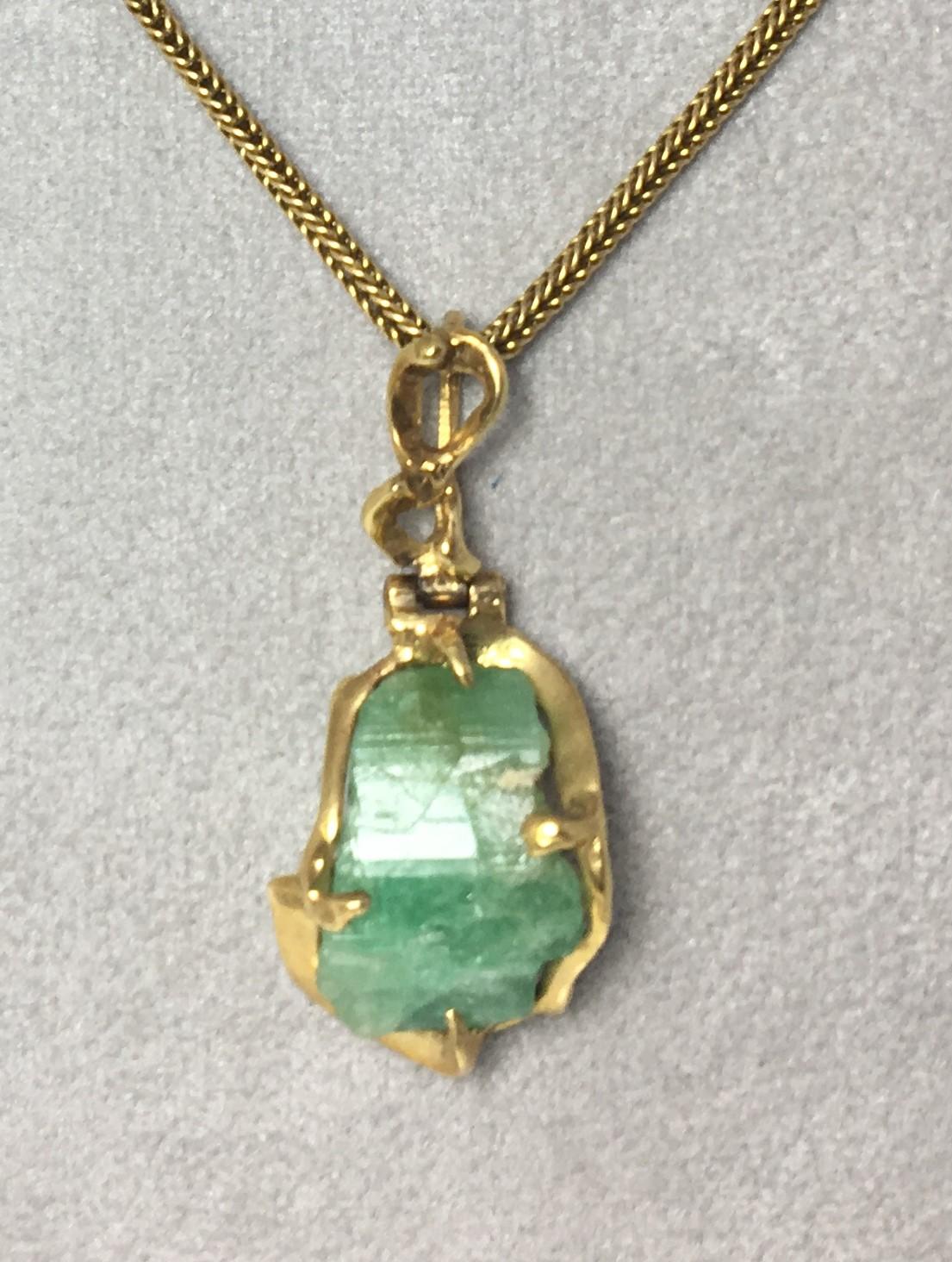 This one-of-a-kind emerald pendant with a custom made 18 karat yellow gold mounting makes a statement.
Rough Cut Emerald approximately 10mm by 20mm.