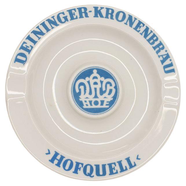 A gorgeous vintage ceramic ashtray in white, with light blue writing around the edges. 

The text reads in blue: 
Deininger -Kronengrau, Hofquell with a crown medallion at the middle. 

The bottom reads in green: Rieber, Bavaria
Bavaria

A