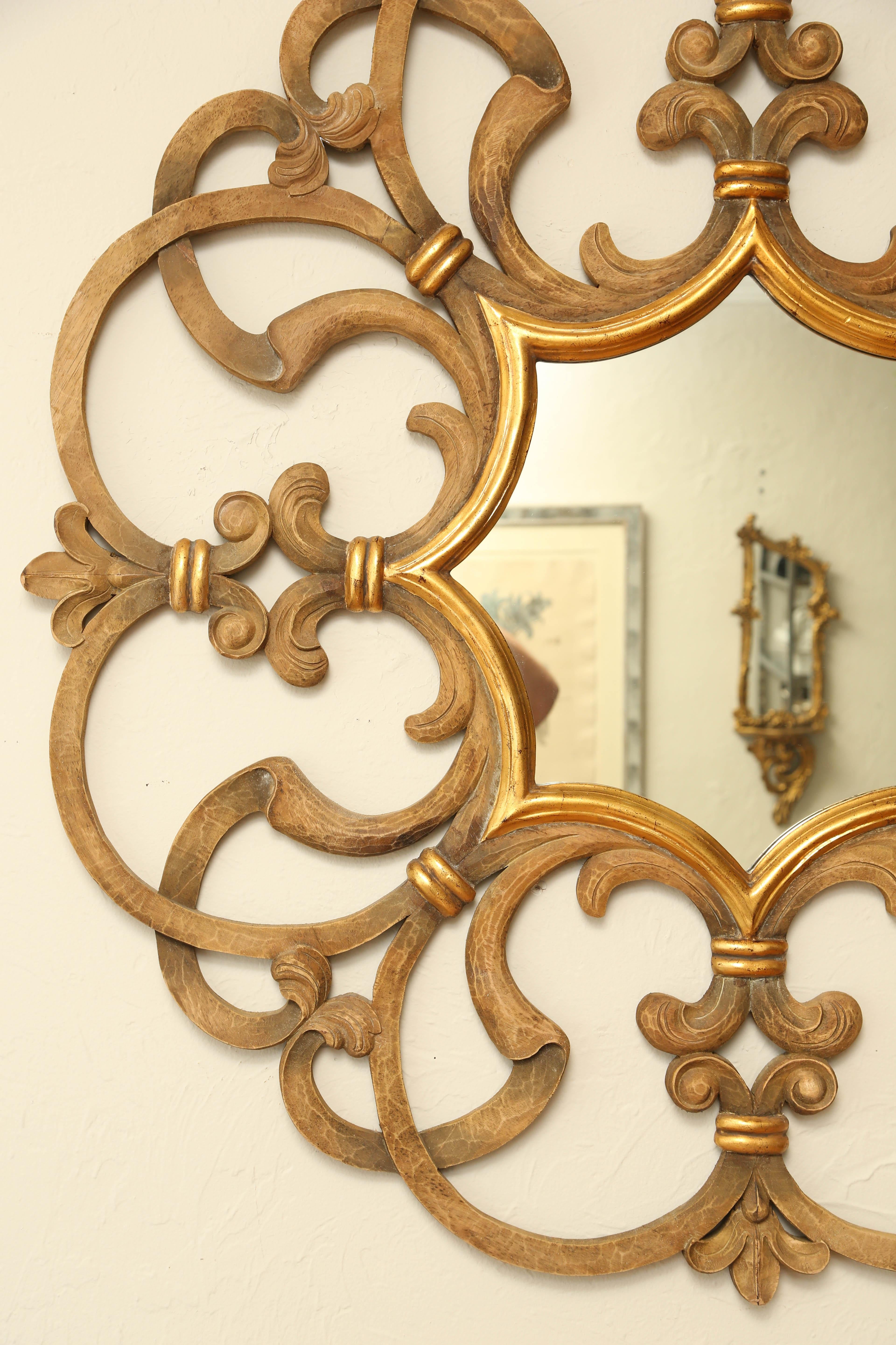 Large scrolled carved and gilded mirror by Harrison Gil.
