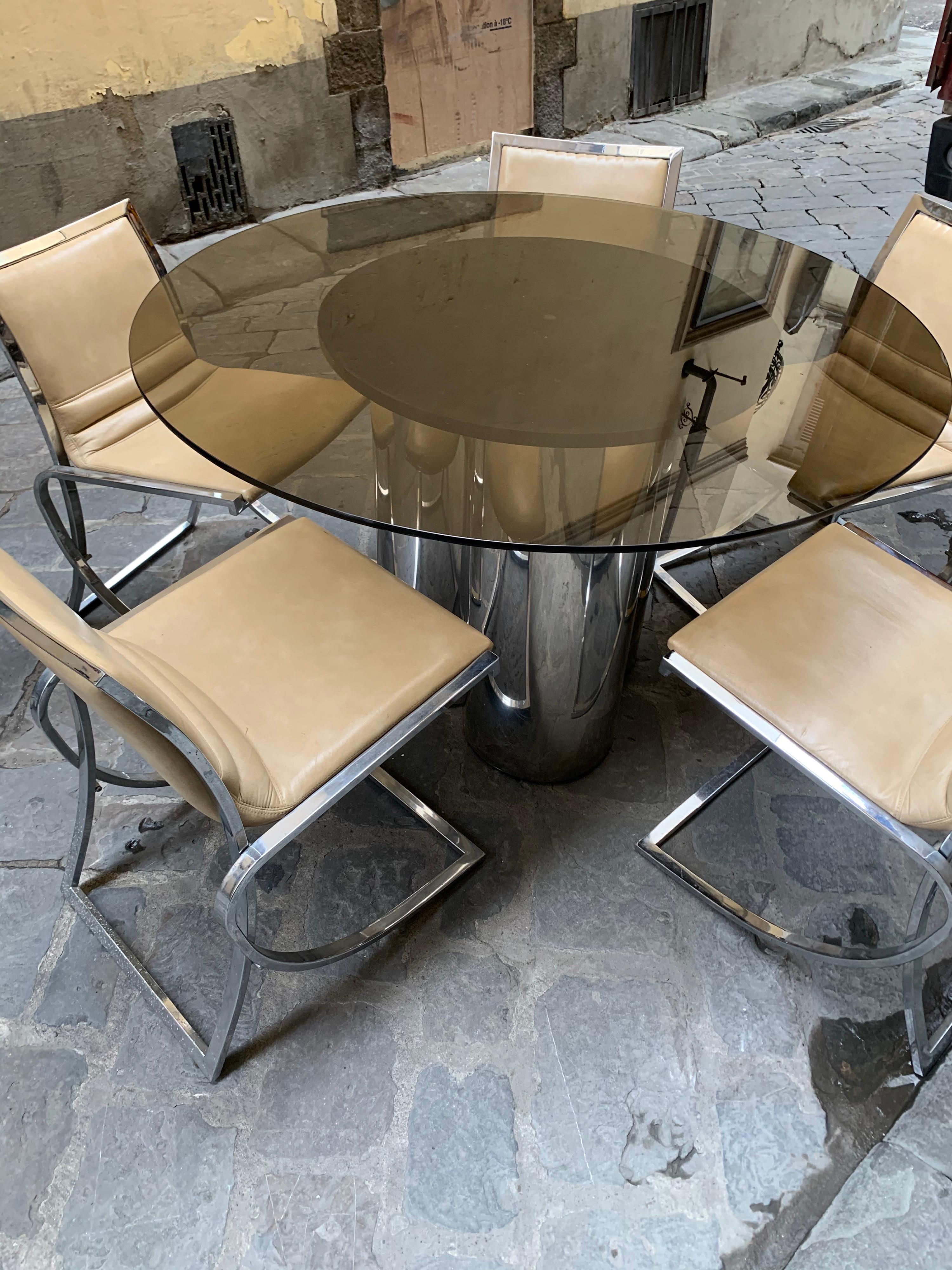Vintage Italian round dining table, with a glass fume top on a trefoil chromed base and set of five chairs, champagne eco-leather, chromed fittings.
Perfect vintage condition.
Table and chairs can be sold individually.
Measurements of the chair: cm
