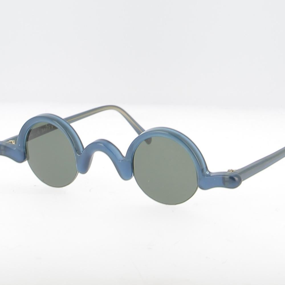 Tauchen Sie ein in die unverwechselbare Eleganz der 1990er Jahre mit diesem Interlude-Rahmen - einer handgefertigten französischen Kreation, die Originalität, Raffinesse und handwerkliches Können perfekt miteinander verbindet.

Dieses einzigartige