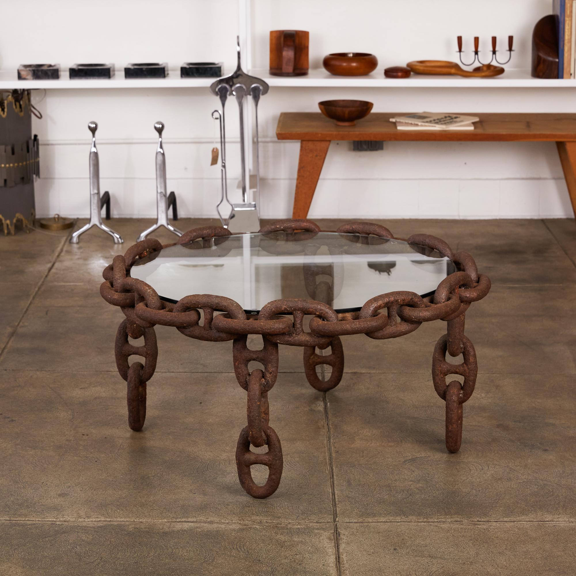 Heavy solid iron stud chain has been skilfully welded to create a perfectly symmetrical round coffee table with four legs. Glass top insets to create the table surface.

Condition: Heavy patinated iron chain. The glass looks to have been replaced