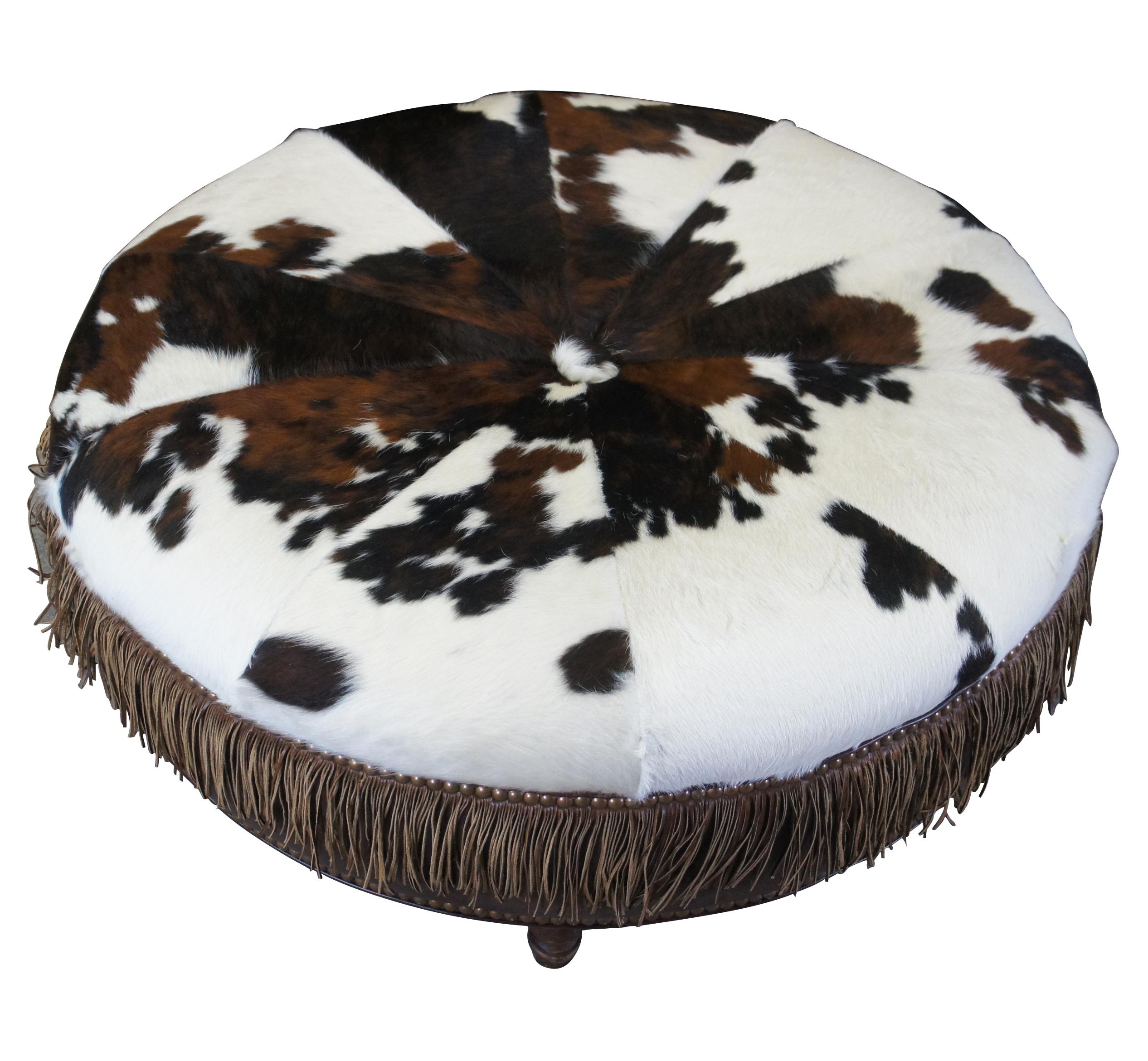 Vintage brown leather and brindled cowhide ottoman / coffee table. Attributed to Vanguard Furniture. Features a round form with button tuft and brown and white hide along the top. The sides are wrapped in a warm brown leather with two layers of
