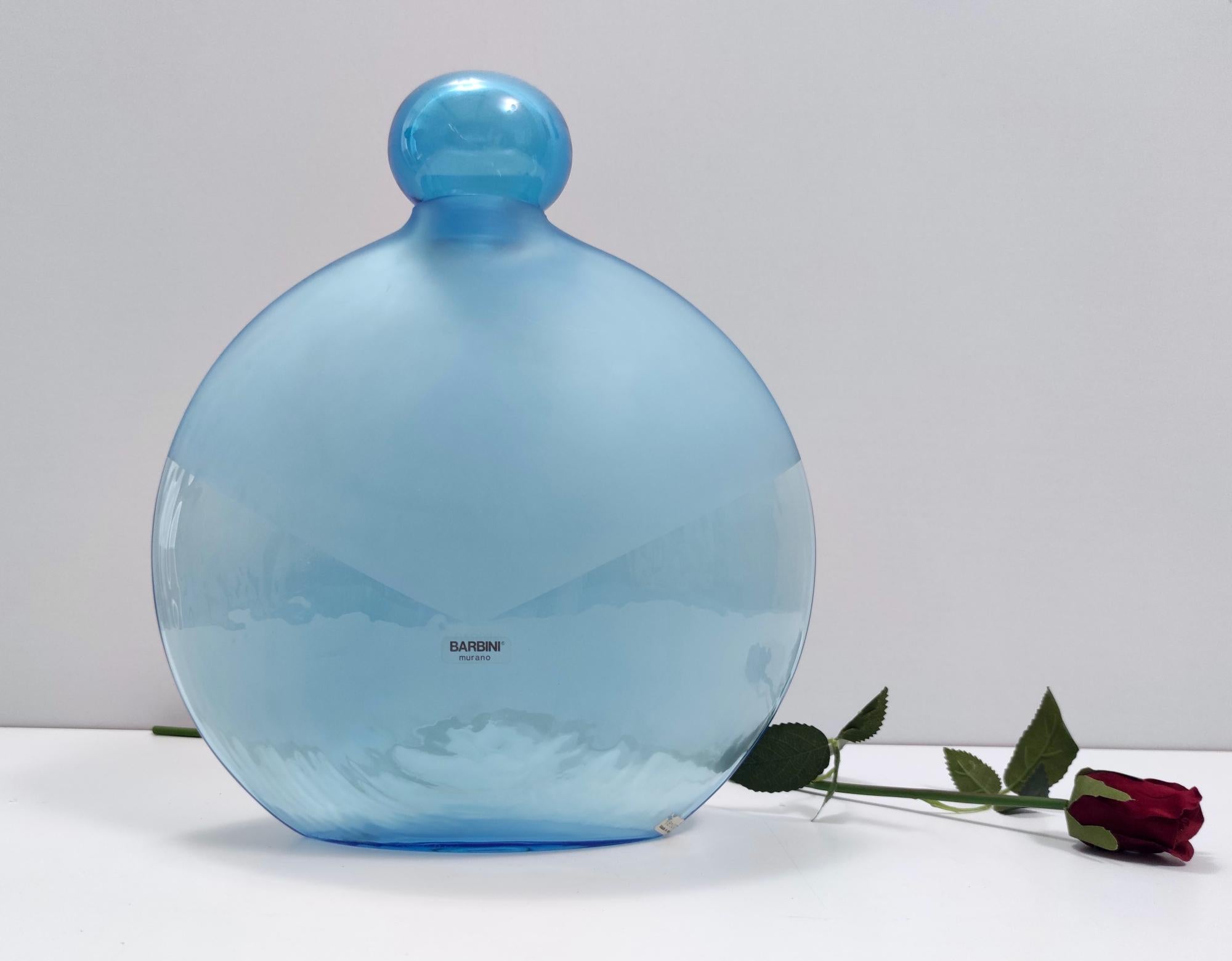 Made in Italy, anni '80.
Questa bottiglia è stata disegnata da Alfredo Barbini ed è realizzata in vetro di Murano e vetro acidato. 
Si tratta di un pezzo vintage, quindi potrebbe presentare lievi tracce d'uso, ma può essere considerato in perfette