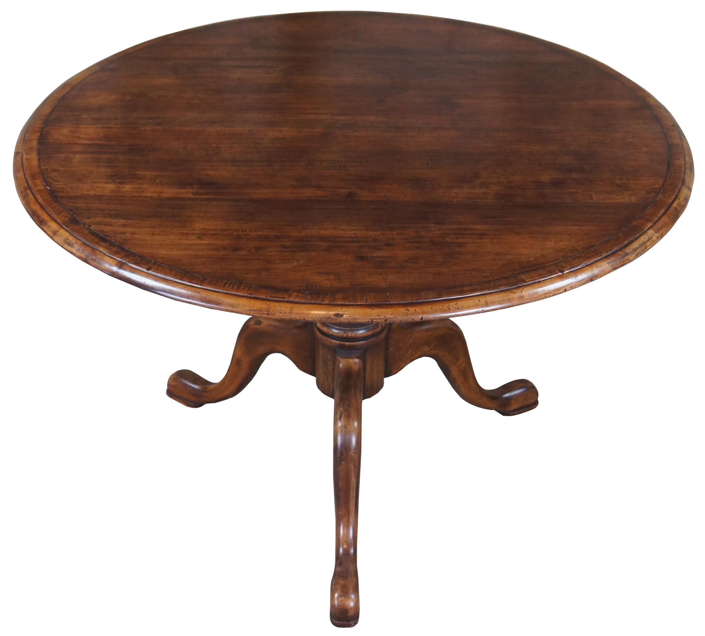 Late 20th century mahogany dining table. A round form top with ogee edge and baluster base with three legs leading to pad feet. Measure: 48