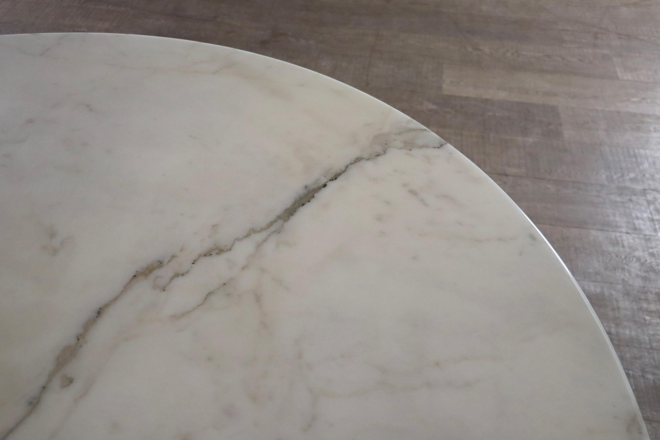 Elevate your dining area with this stunning vintage round marble tulip dining table, designed by renowned designer Eero Saarinen and manufactured by Knoll International in the 1970s. Made of Carrara marble and metal. 

This is the 137cm large