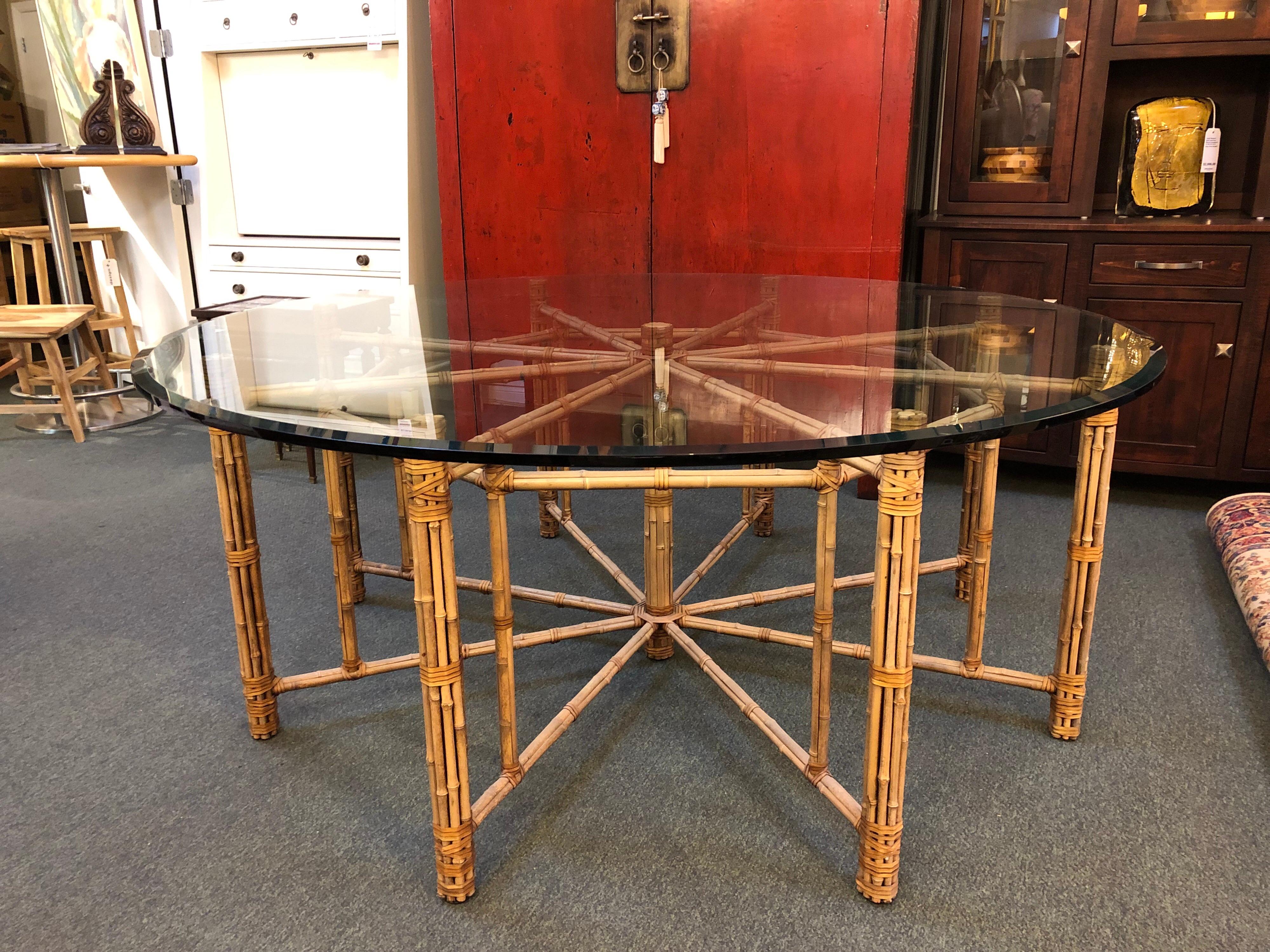 A large McGuire dining table. Designed by John McGuire. Beautiful bamboo rods are lashed together with McGuire's signature raw hide lacing in an intricate pattern that comfortably seats eight. The base is topped with 3/4