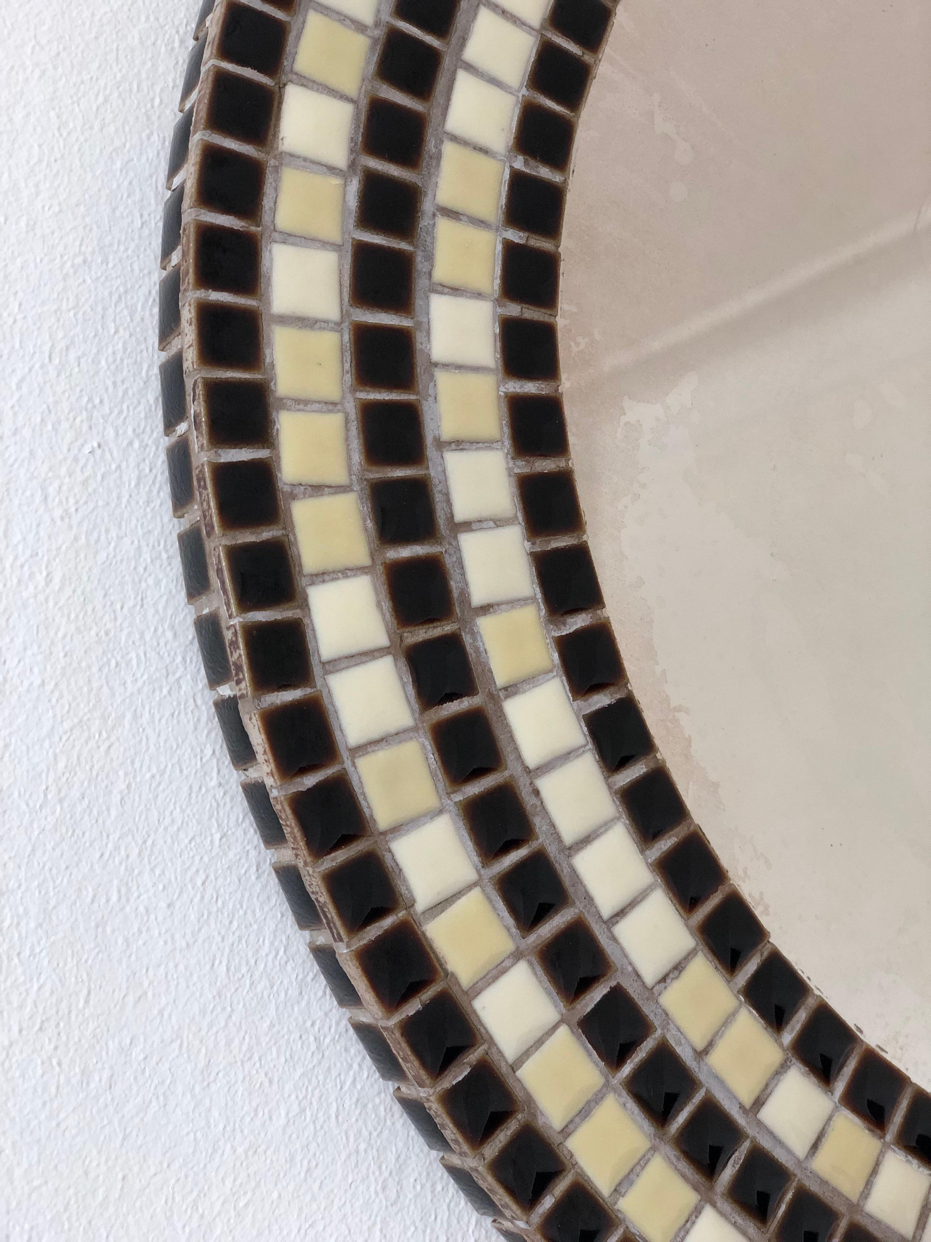 Miroir mural rond vintage des années 1970, doté d'un cadre en mosaïque avec des carreaux noirs, crème et blancs dans un motif audacieux et graphique. Une pièce élégante qui ajoute une touche de charme rétro à n'importe quel espace.

Objet :