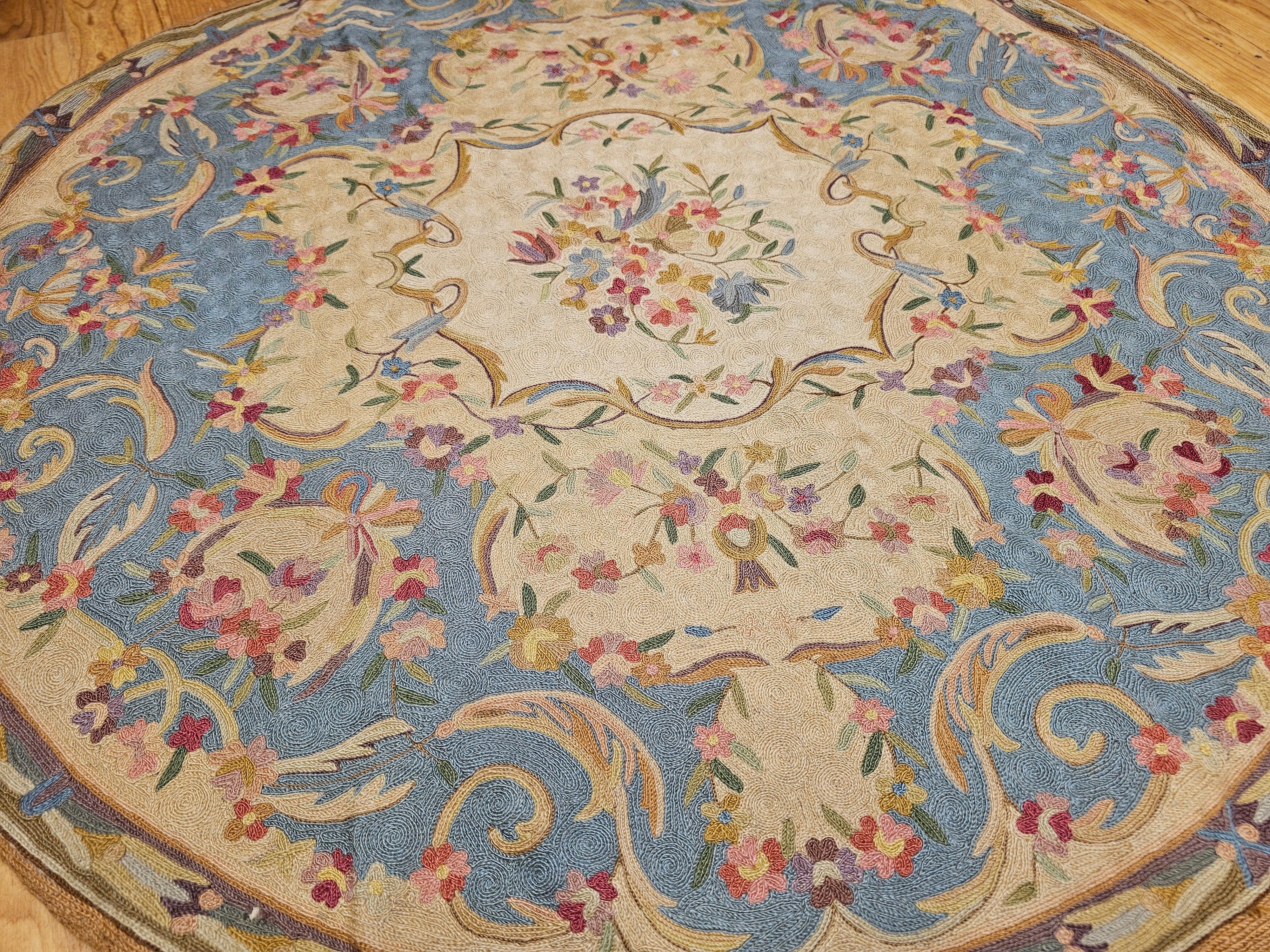 Alfombra redonda vintage de punto de aguja con motivos florales en azul pálido, rojo y marfil Hecho a mano en venta