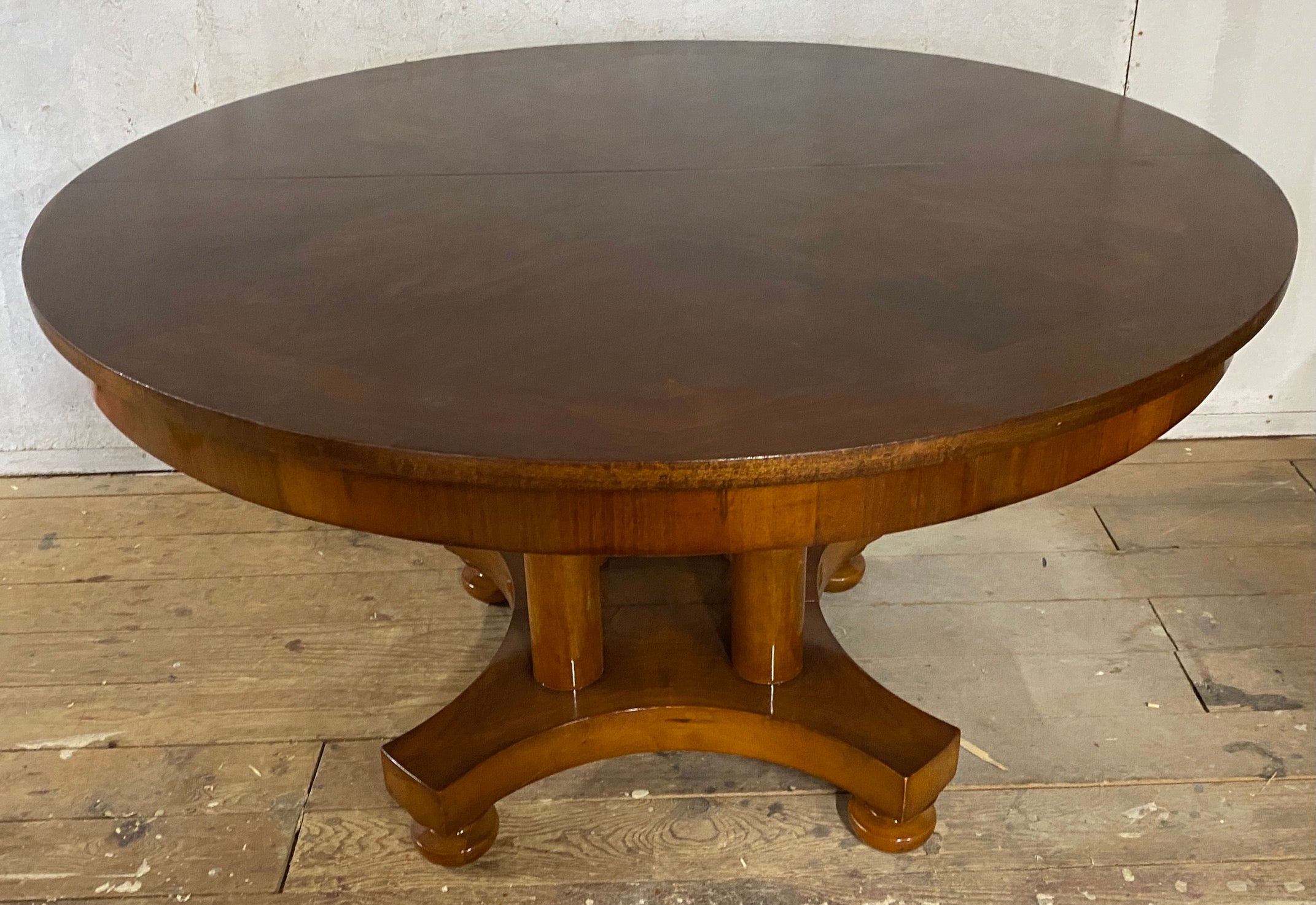 A handsome round Regency style center pedestal dining table.
The base has four pillar legs attached to a center platform and round ball feet. The table has been newly restored. Although it can be opened and extended, it does not have any