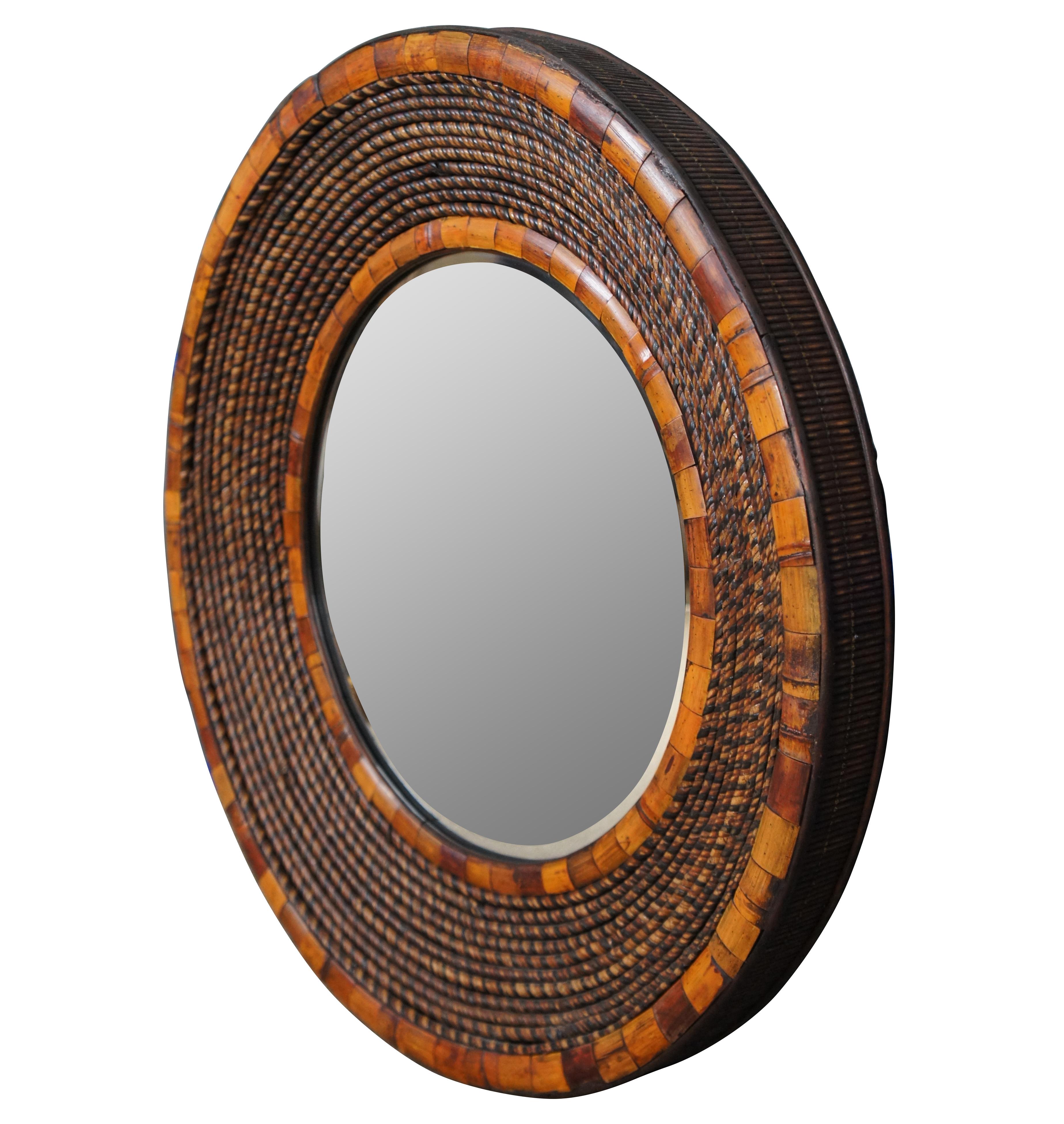 Round modern bullseye beveled wall vanity mirror framed with ropes of multi-toned twisted rattan / split reed wood, edged with rounded pieces of cut bamboo.

Provenance:
Estate of J. Frederic Gagel, owner of multiple Thoroughbred race horses that