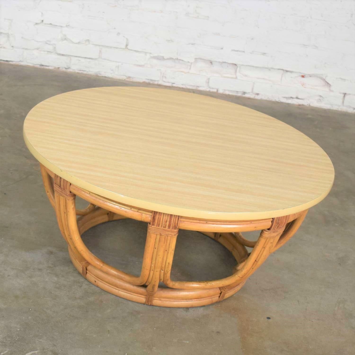 Handsome round rattan drum shape coffee table or end table with laminate top. It is in wonderful vintage condition with no outstanding flaws only normal wear for age. Laminate top may be a replacement top at some point in its life but looks