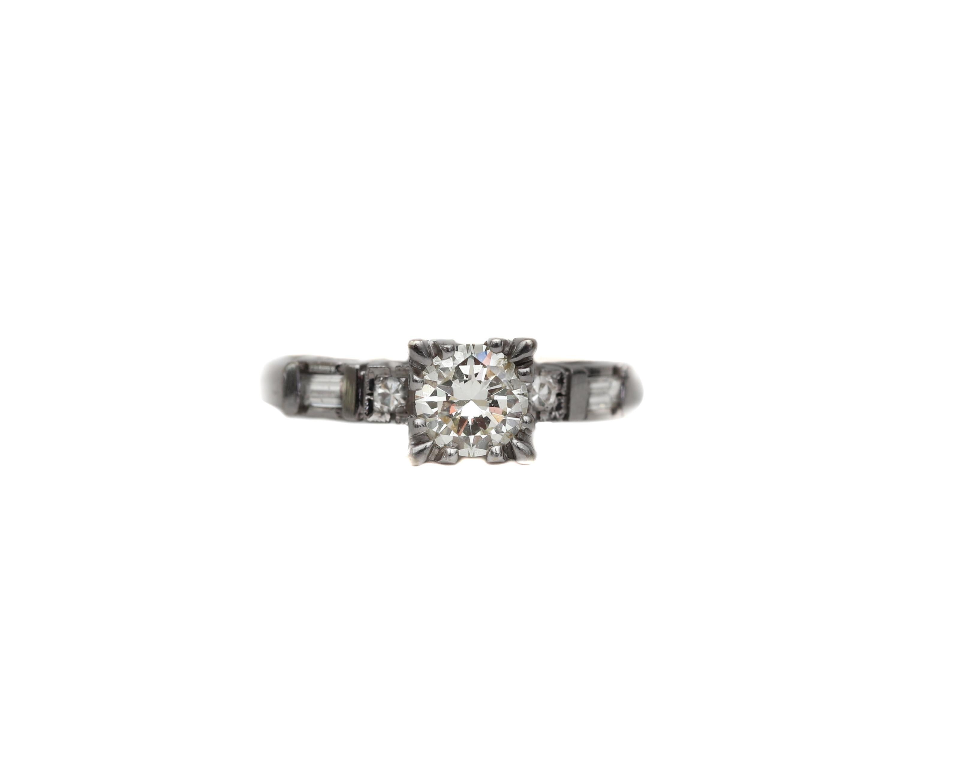 This classic diamond engagement ring features a lively .65 carat transition cut solitaire (in between early old european cuts and modern round brilliants) set in the center with squared head. Smaller round and baguette cut diamonds flank the center