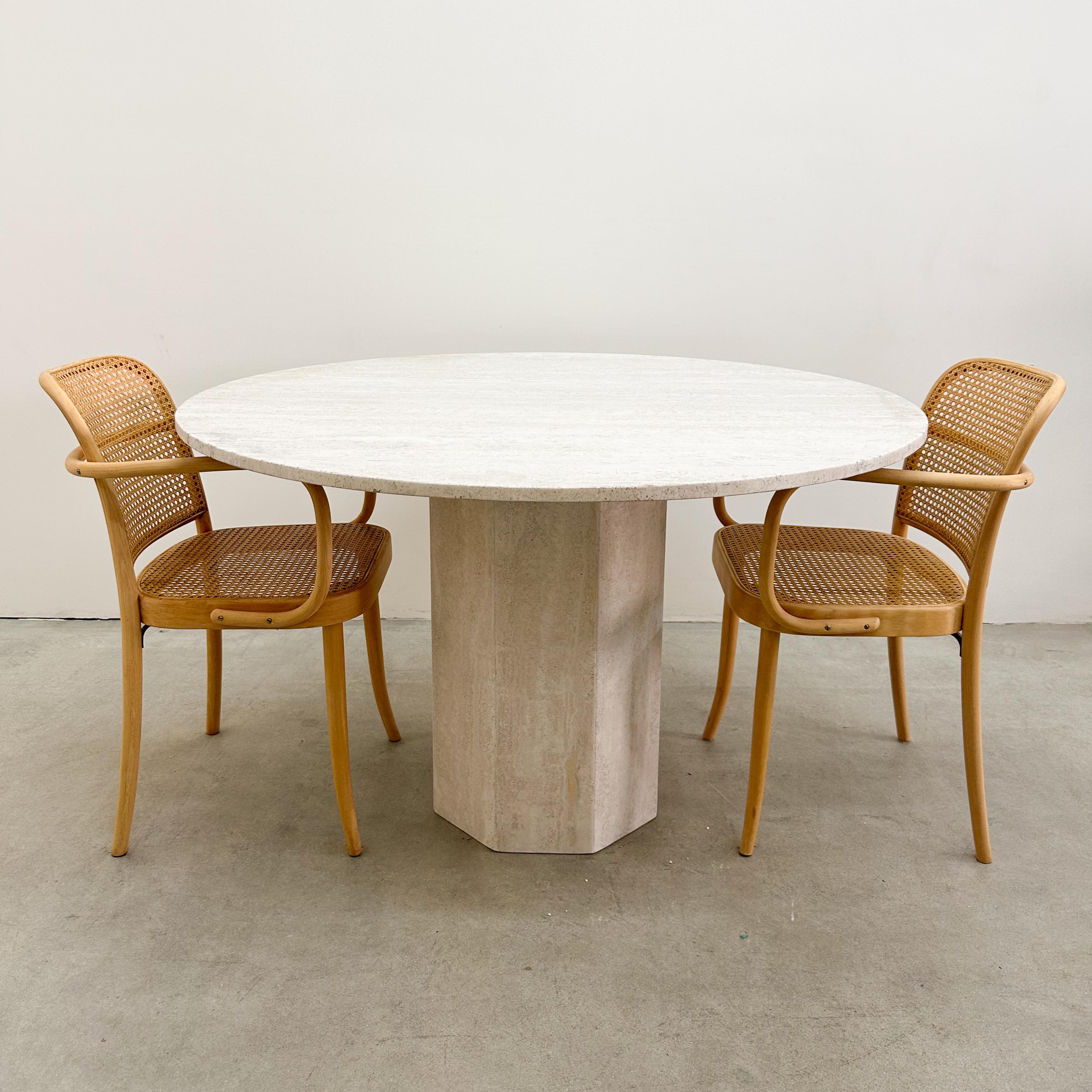 This vintage round travertine dining table from the late 1970s embodies timeless elegance and Mid-Century Modern design. The solid travertine top rests on a sturdy pedestal base, creating a sculptural yet functional piece that blends seamlessly into