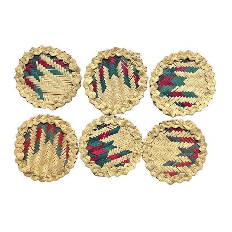 A set of six woven raffia drink coasters. This vintage set will be a great addition to your barware. Woven from light raffia, each coaster has a woven center in a brown, green, and pink herringbone pattern. Each is very thick and will soak up any