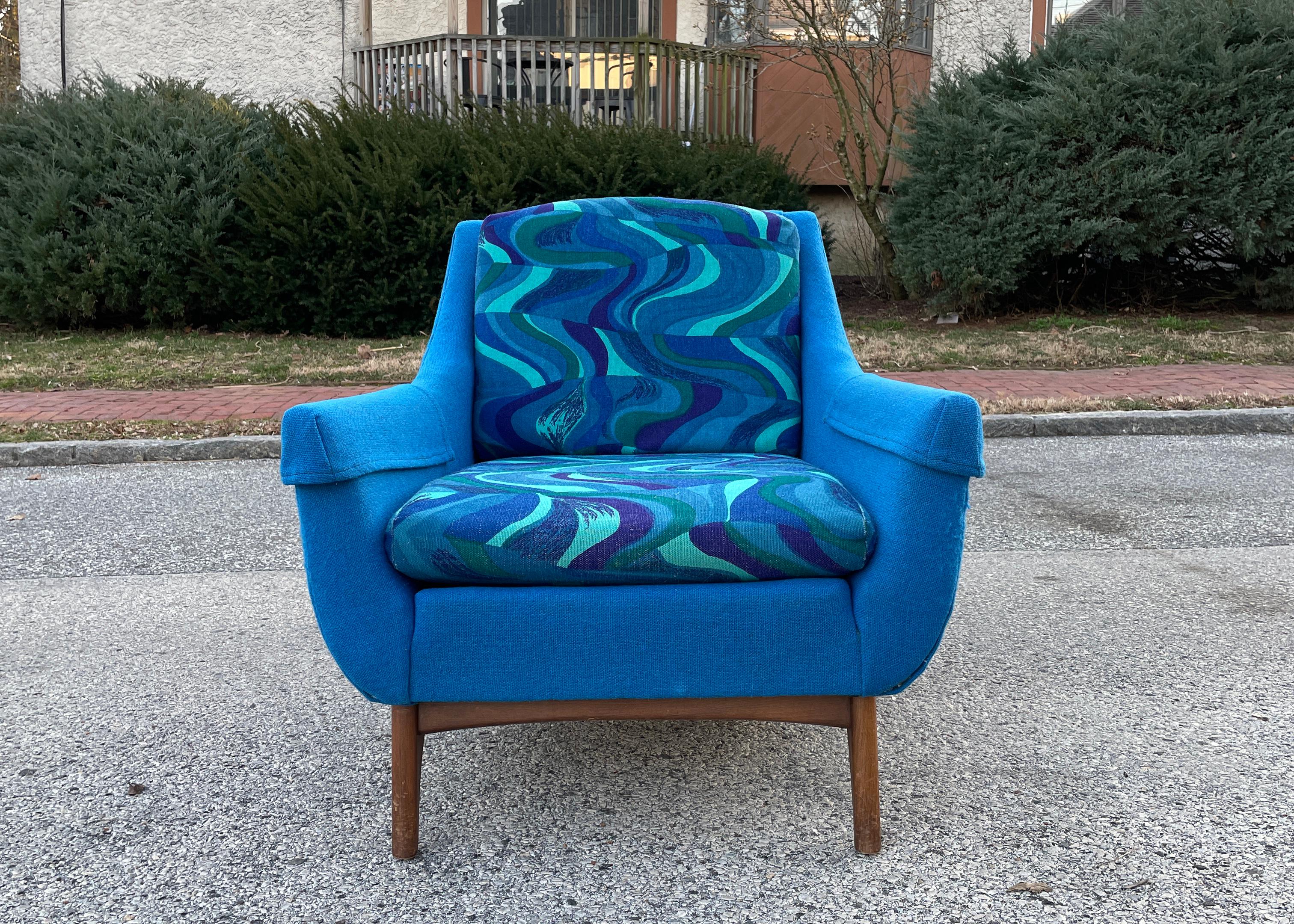 A stunning psychedelic upholstered armchair by the American company Rowe Furniture. Sporting sculpted walnut legs and mesmerizing fabric, this chair is sure to serve as a cozy conversation starter in your home. Beyond its brilliant looks, the chair